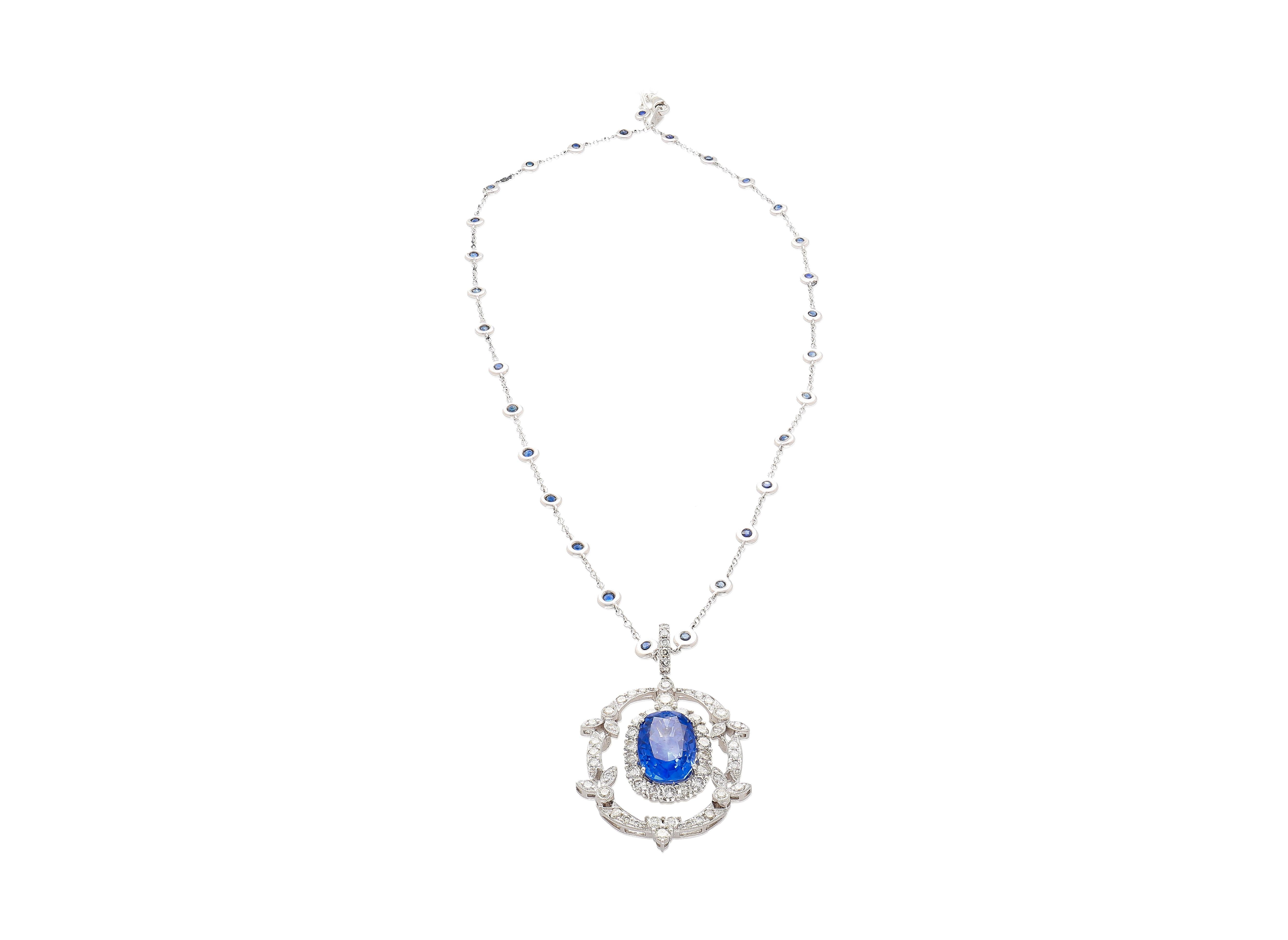 Vintage Victorian-style Blue Sapphire and Diamond pendant necklace in 18K white gold. Featuring a 10.36 carat no heat oval cut Blue Sapphire of Sri Lankan origin. The center stone is a vibrant deep blue saturation with excellent luster and