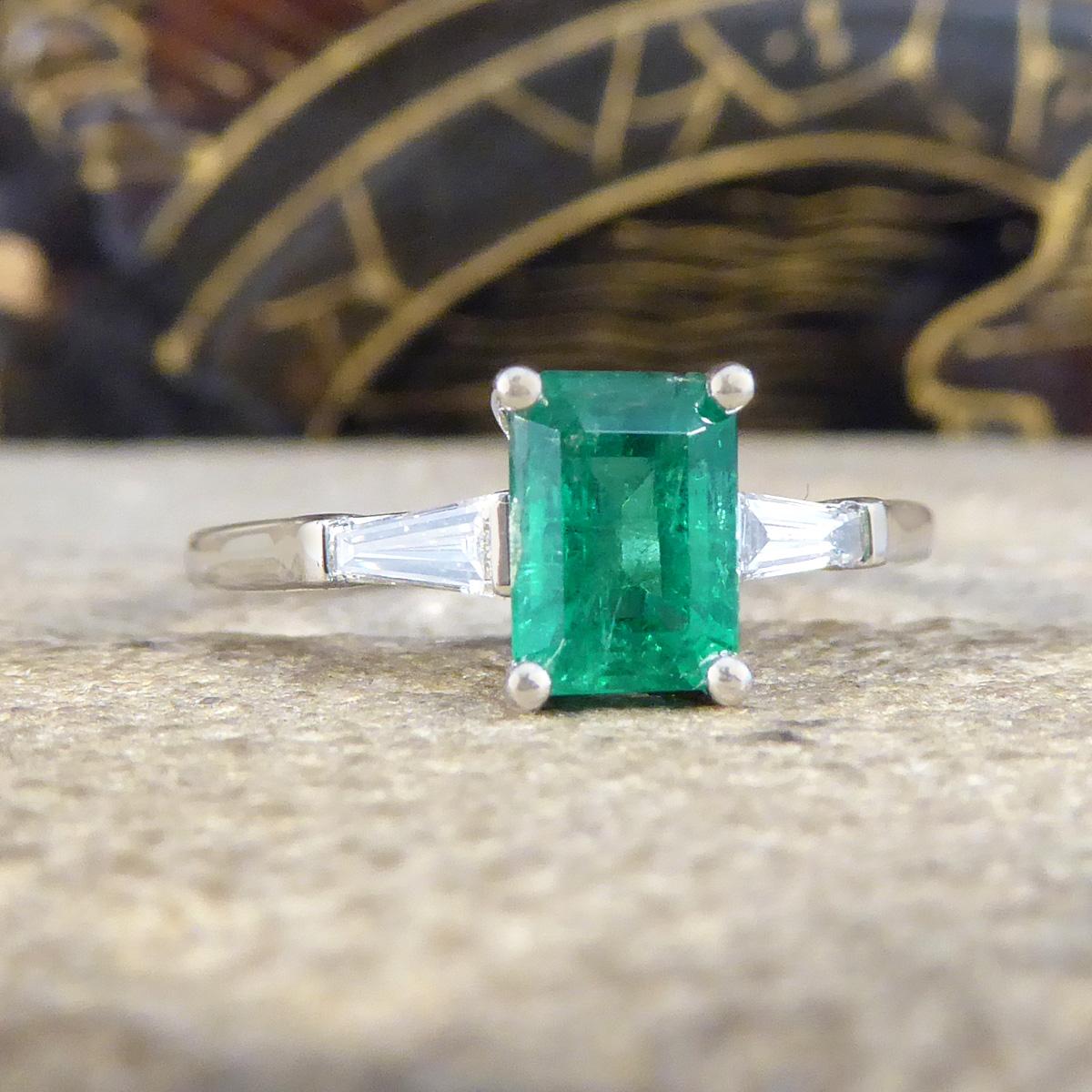 This ring features and holds a very mesmerising green Emerald in the centre. The Emerald itself is in great condition with sharp facets, it has such a vibrant green colour to it with regular natural Emerald flaws within the stone. Accompanying the