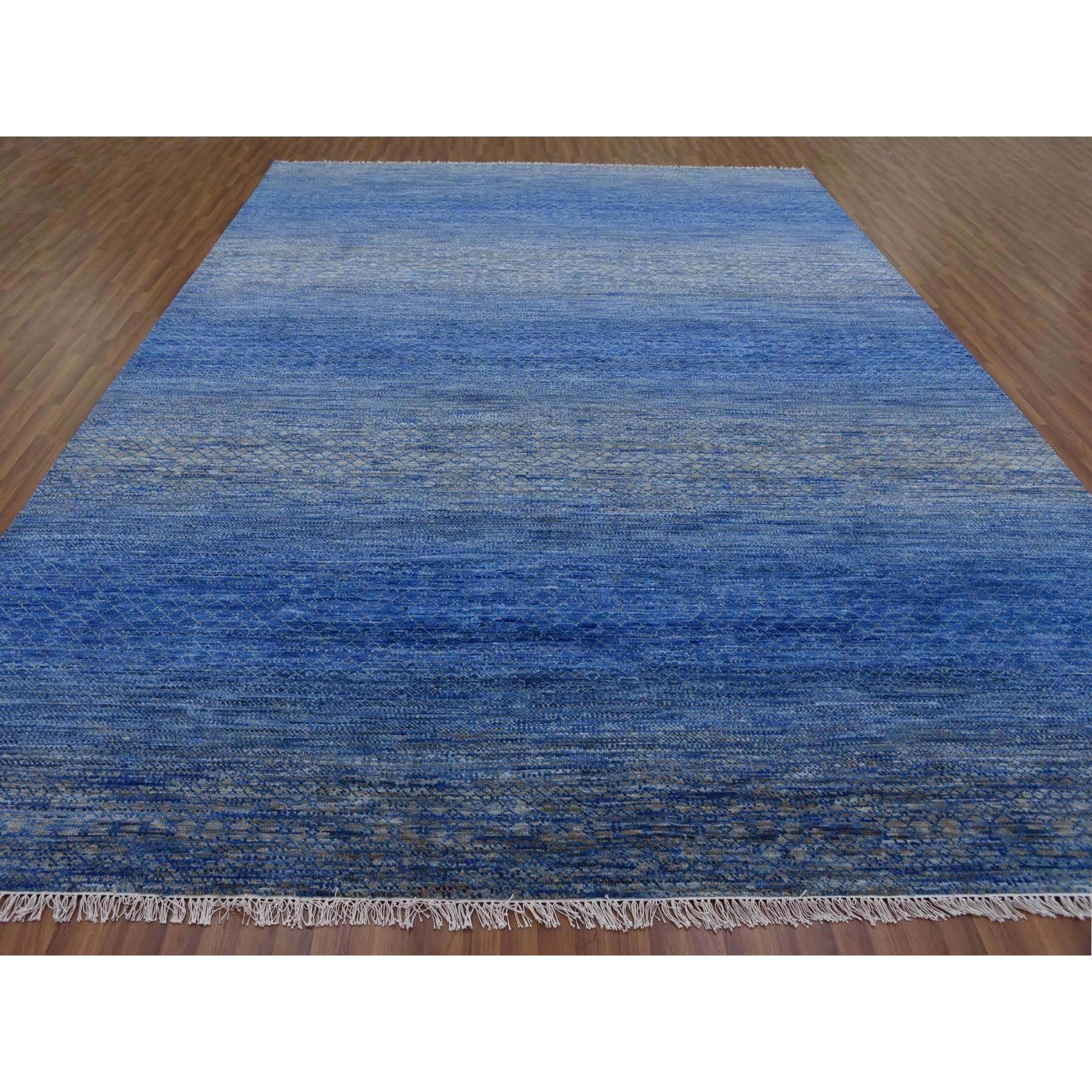 Il s'agit d'un véritable tapis d'Orient bleu denim, épais et pelucheux, en pure laine, noué à la main, de la collection moderne Chiaroscuro. Il a été noué pendant des mois et des mois selon des techniques de tissage séculaires par des artisans