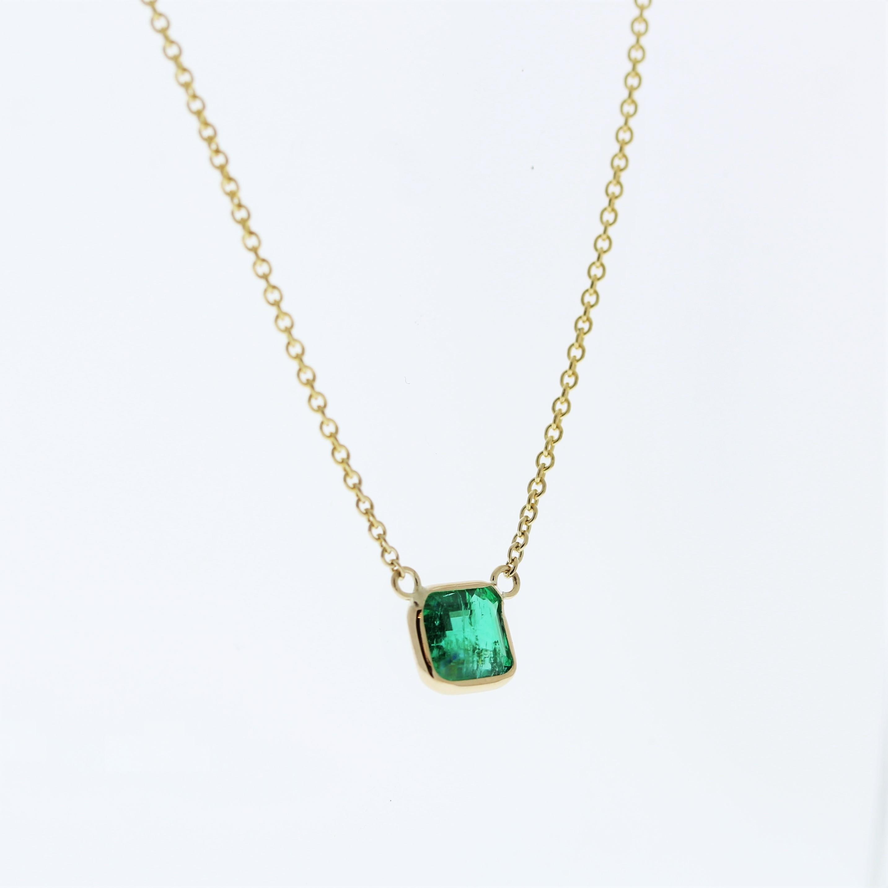 The necklace features a 1.04-carat Asscher-cut green emerald set in a 14 karat yellow gold pendant or setting. The distinctive Asscher cut and the vivid green color of the emerald against the yellow gold setting are likely to create an elegant and