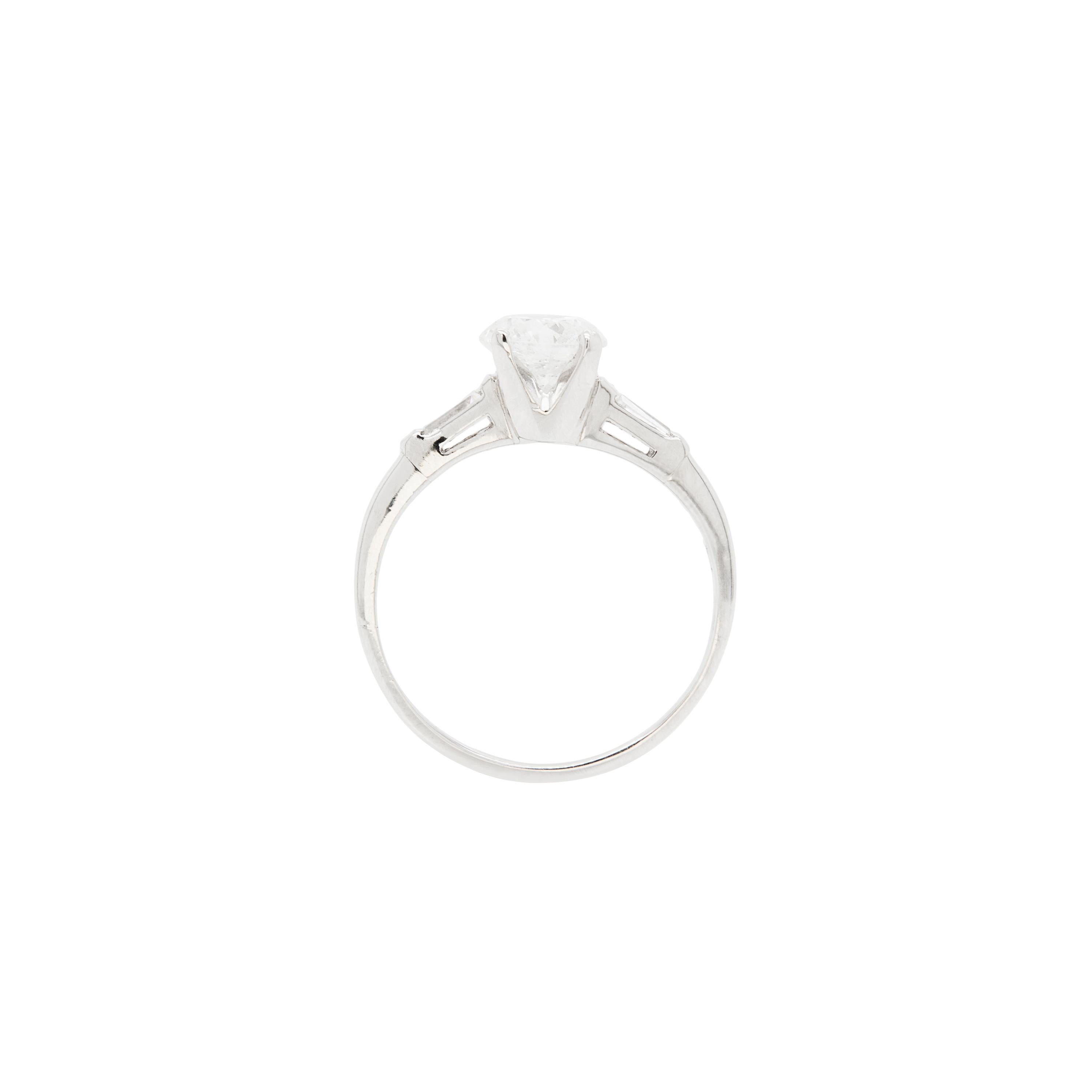 This absolutely stunning three stone engagement ring is definitely a beauty!

At the centre of the piece is a striking 1.04ct round brilliant cut diamond elegantly set in a delicate four claw, open back platinum setting, that enhances the stone's