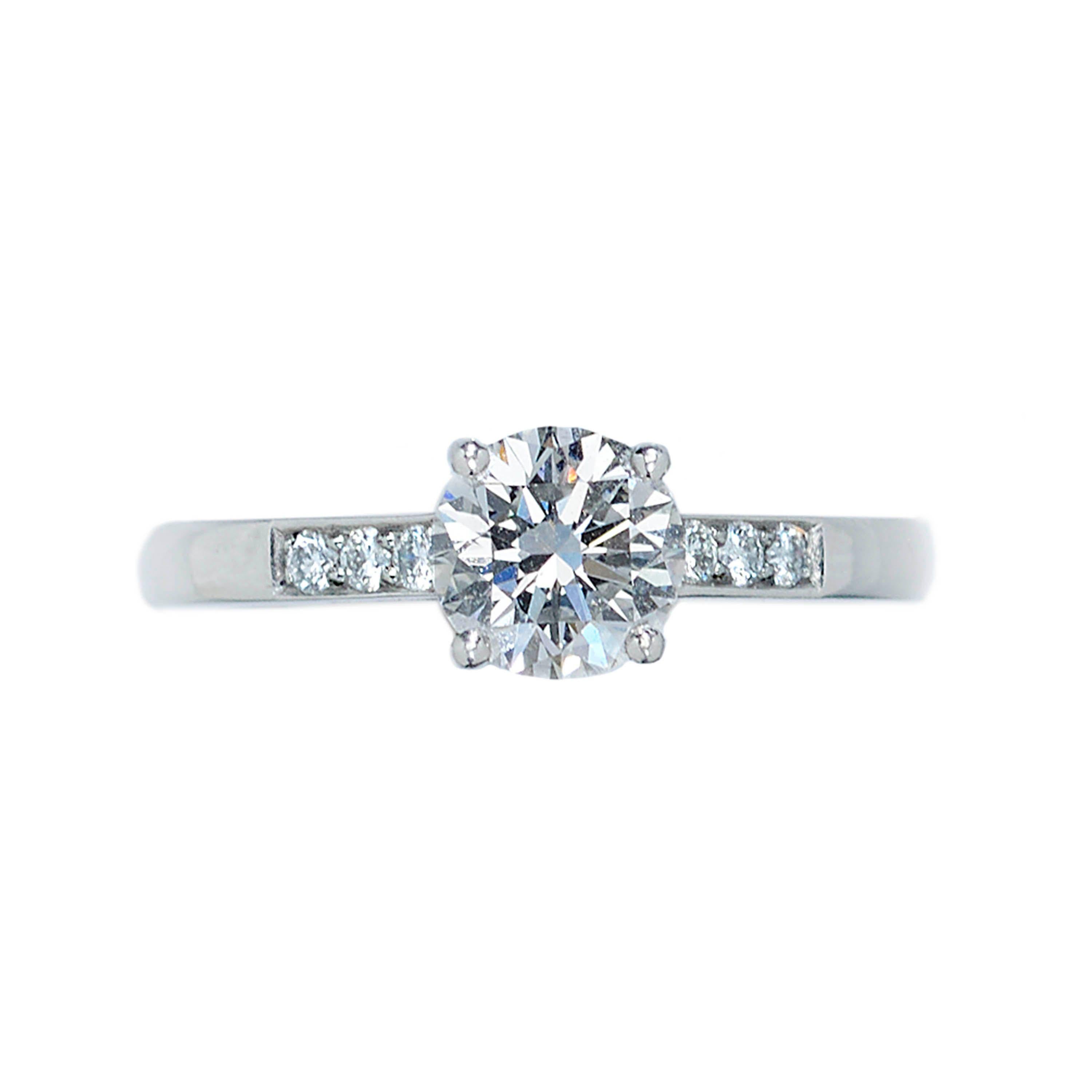 A diamond solitaire ring, set with a 1.04ct, F colour, VS1 clarity, round brilliant-cut diamond, in a four claw setting, with three round brilliant-cut diamonds pavé set in each shoulder, with a total weight of 0.11ct, mounted in platinum,