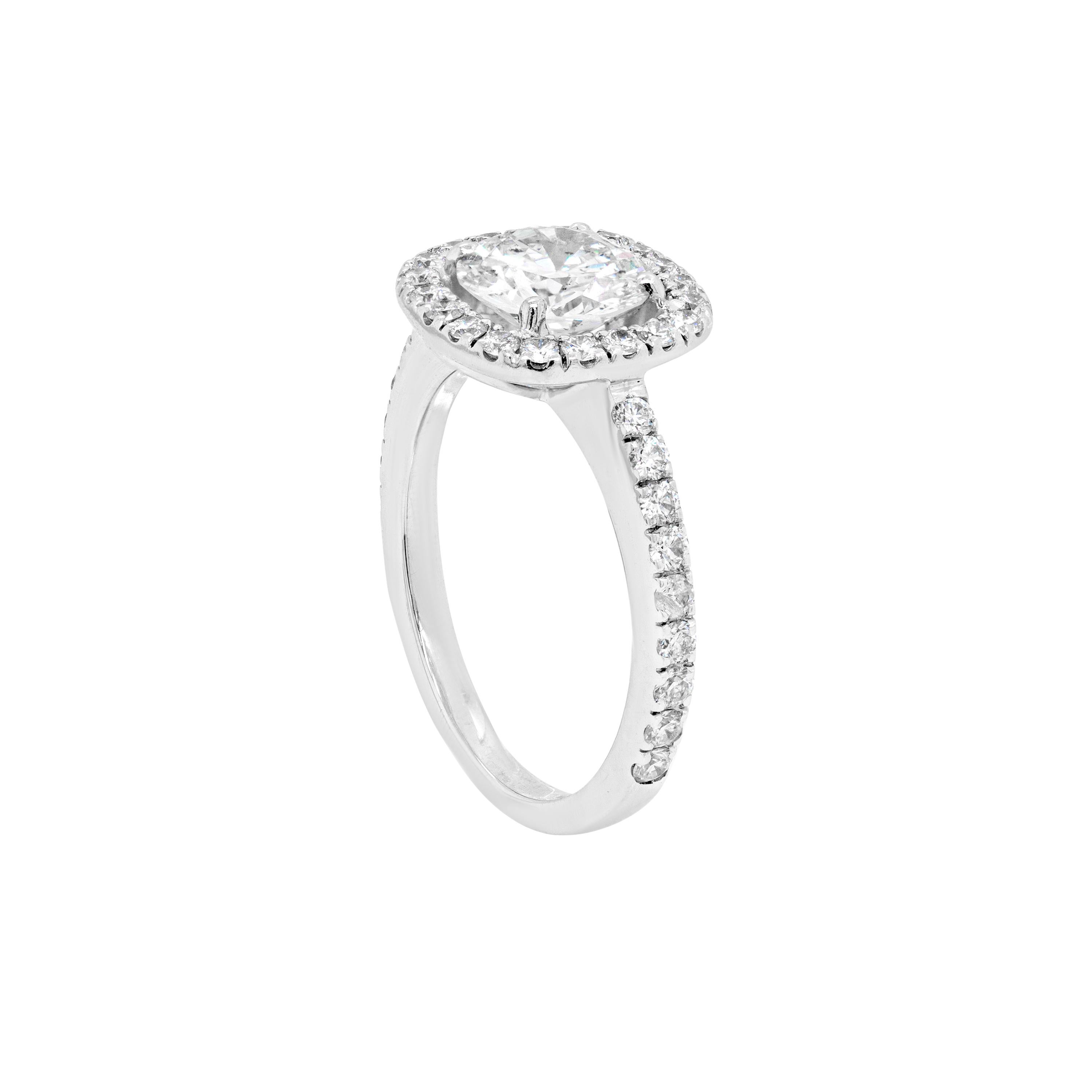 This absolutely gorgeous 18 carat white gold engagement ring features a round brilliant cut diamond weighing 1.04ct, certified 'H' in colour and 'Si1' in clarity. The beautiful stone is surrounded by a halo of 20 round brilliant cut diamonds to