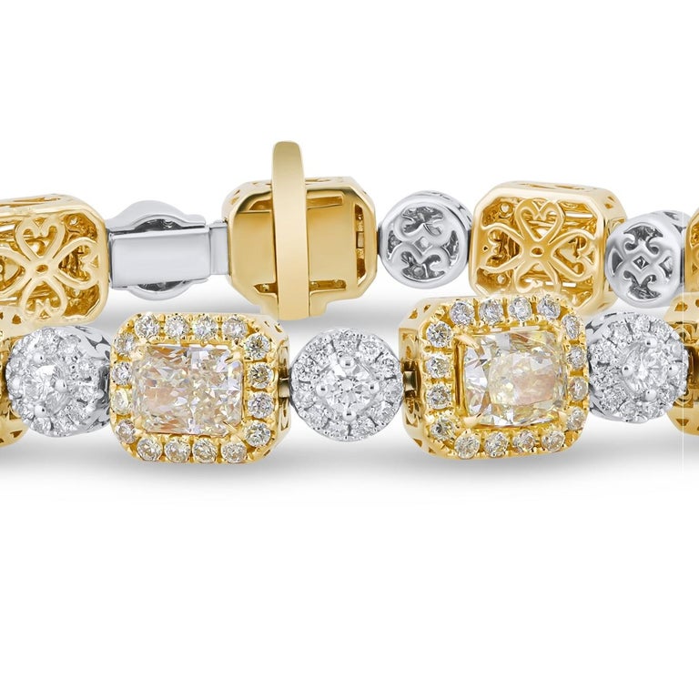 This gorgeous bracelet will be a classic addition to your jewelry box. Thirteen cushion cut yellow diamonds (total weight 7.4 carats) are surrounded by halos of round yellow diamonds (total weight 1.64 carats). These alternate with links of round