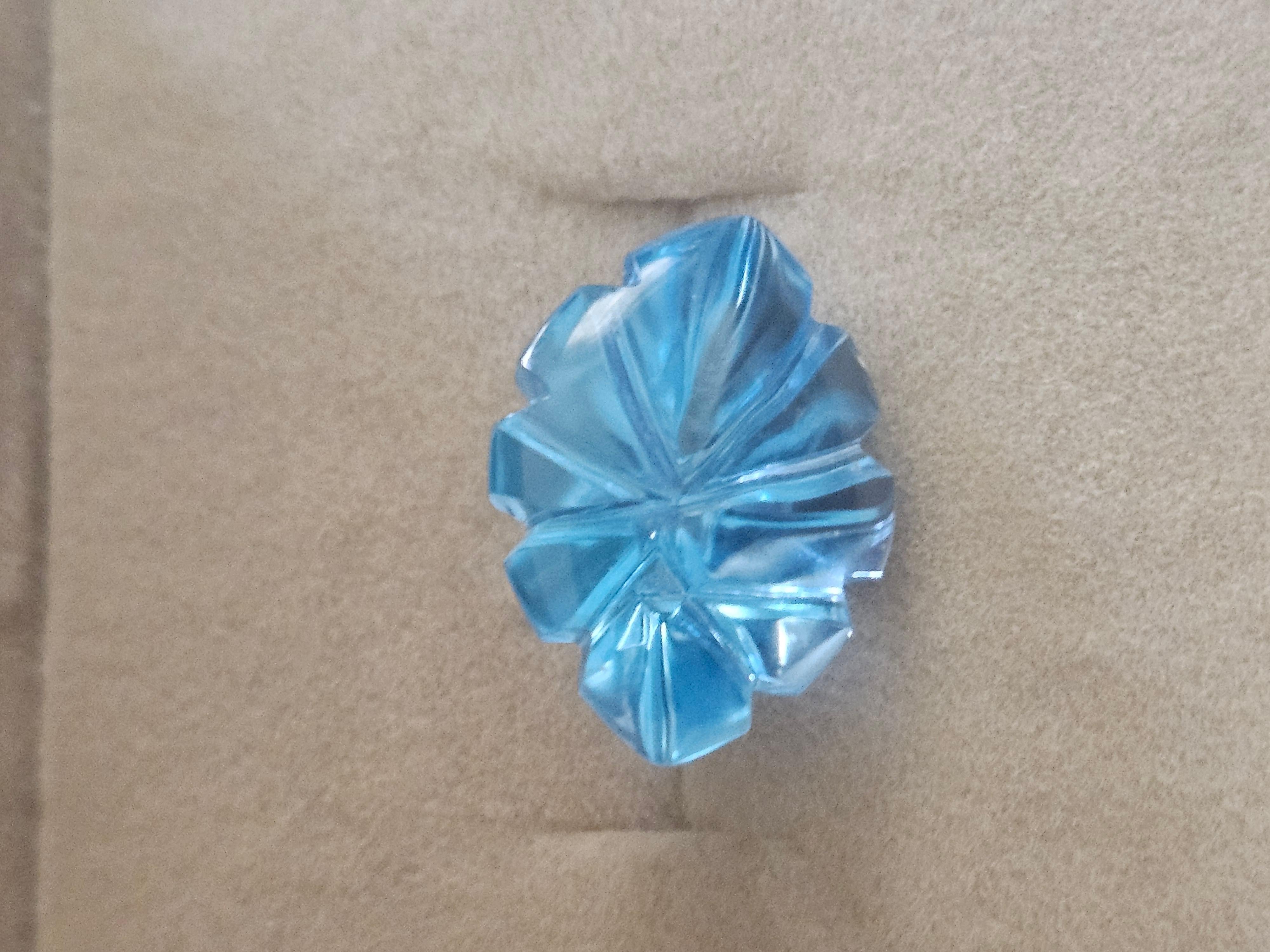 The product is a 10.4 ct. fantasy cut sky blue topaz gemstone in the shape of a marquise. This gemstone is specifically cut in a floral pattern, giving it a unique and elegant design. With its vibrant sky blue color and intricate marquise shape,