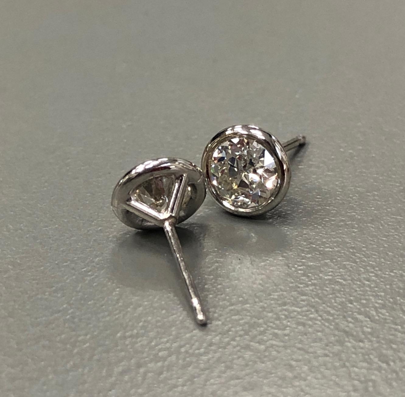 The 14 Karat white gold bezel set diamond stud earrings, weighing 1.04 carat in total, are centered on 2 transitional circular cut diamonds H-I Color SI2-VS2 Clarity. Evoking a vintage look, these are truly stunning. 