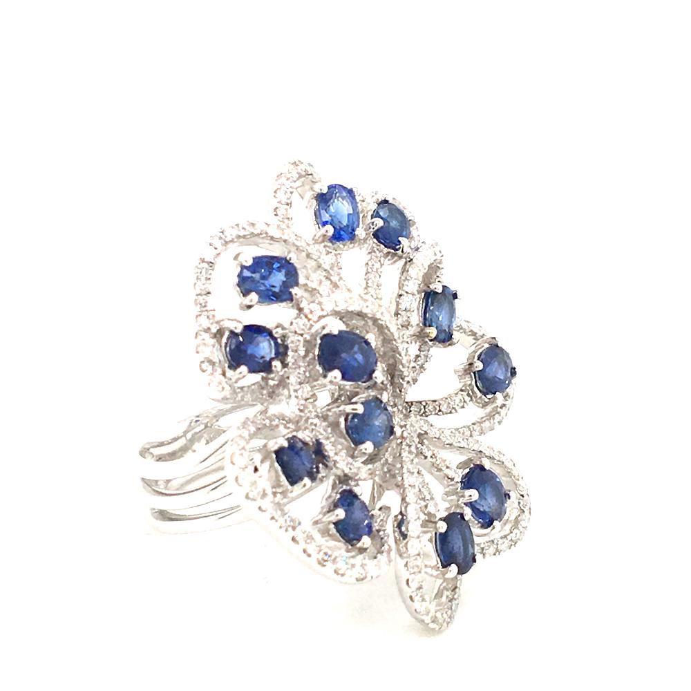 18 KT White gold ring in a Flower motif
set with round diamonds G color VS clarity
and 12 Oval Blue sapphire 
Made In Italy comes in Box
finger size 11 Italian Size (adjustable)