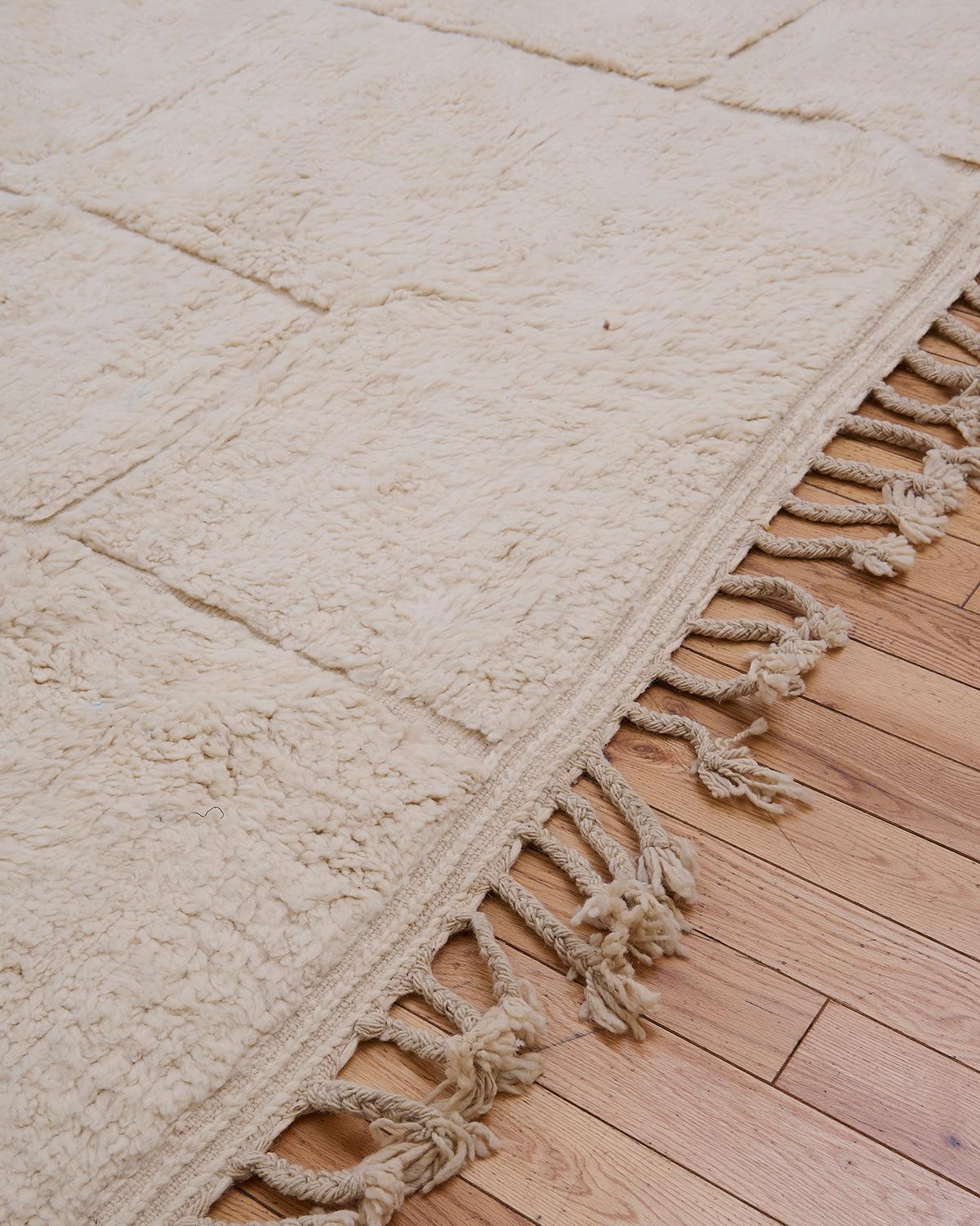 The Espirit rug is a magnificent Beni Ouarain piece, handwoven by Berber artisans in the Atlas Mountains of Morocco. Featuring a soft, cream background, this rug showcases intricate, minimalist geometric patterns that are typical of the Beni Ouarain