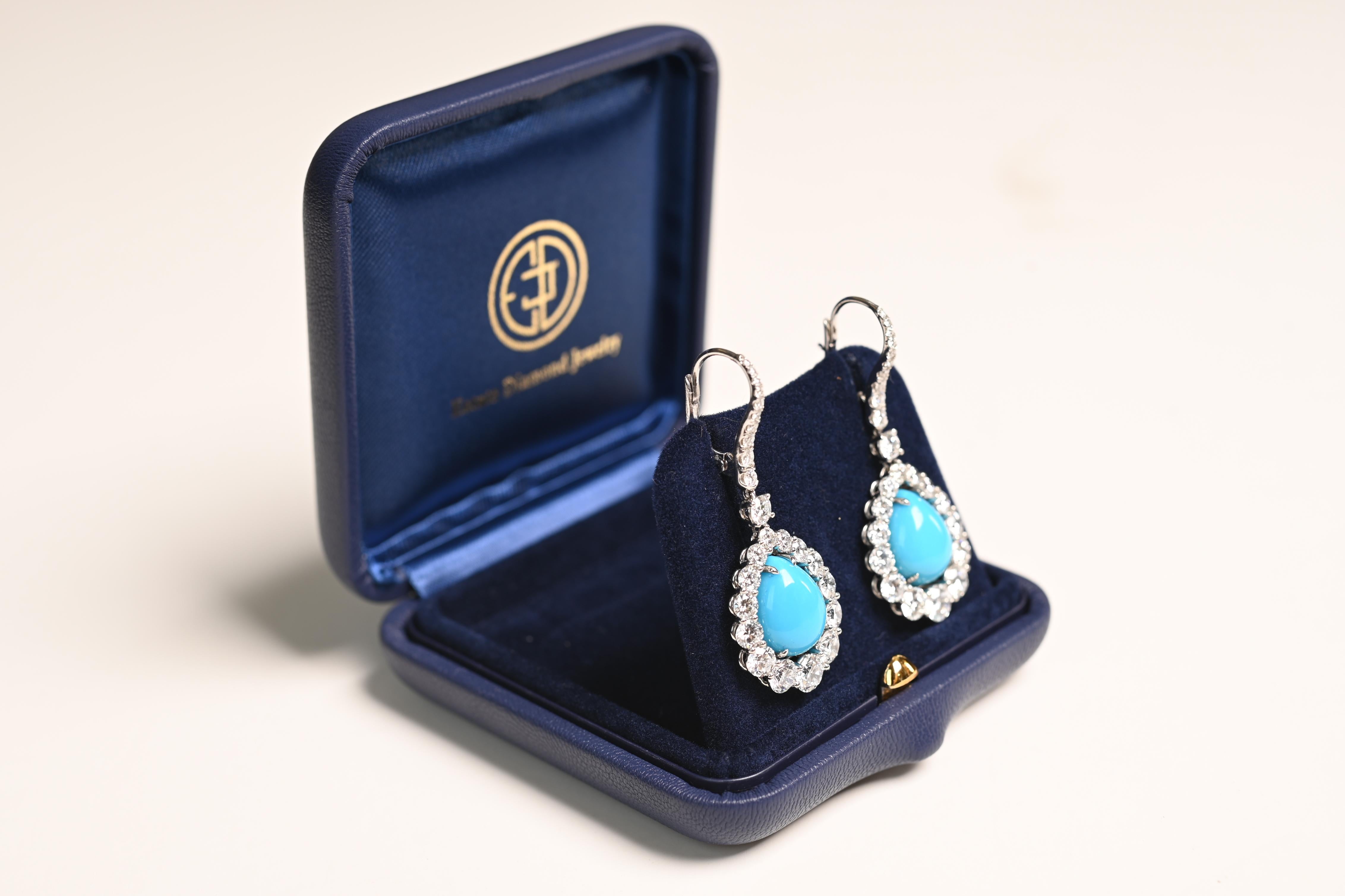 A stunning pair of Soroca earrings, exquisitely crafted in platinum, featuring vibrant cabochon turquoise centers with a total weight of approx 10.40-carats. The turquoise stones are elegantly prong-set, showcasing their rich, captivating hue.