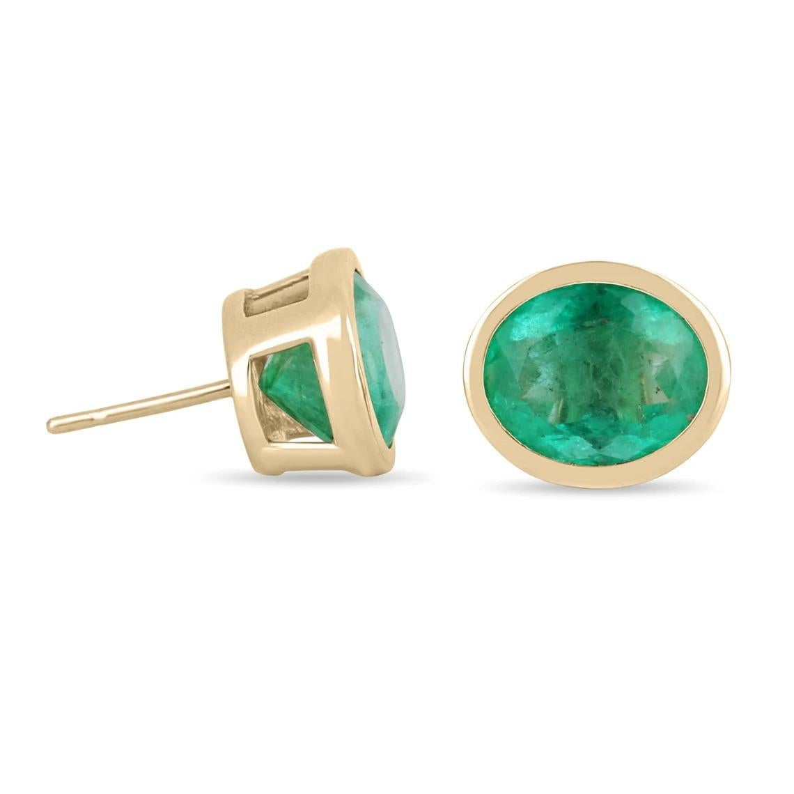 Displayed are gorgeous bezel set natural oval Colombian emeralds yellow gold bezel statement studs in solid 14K. Make a stylish statement with these beauties. These 14k gold stud earrings are handmade by our expert jeweler and sparkle with an