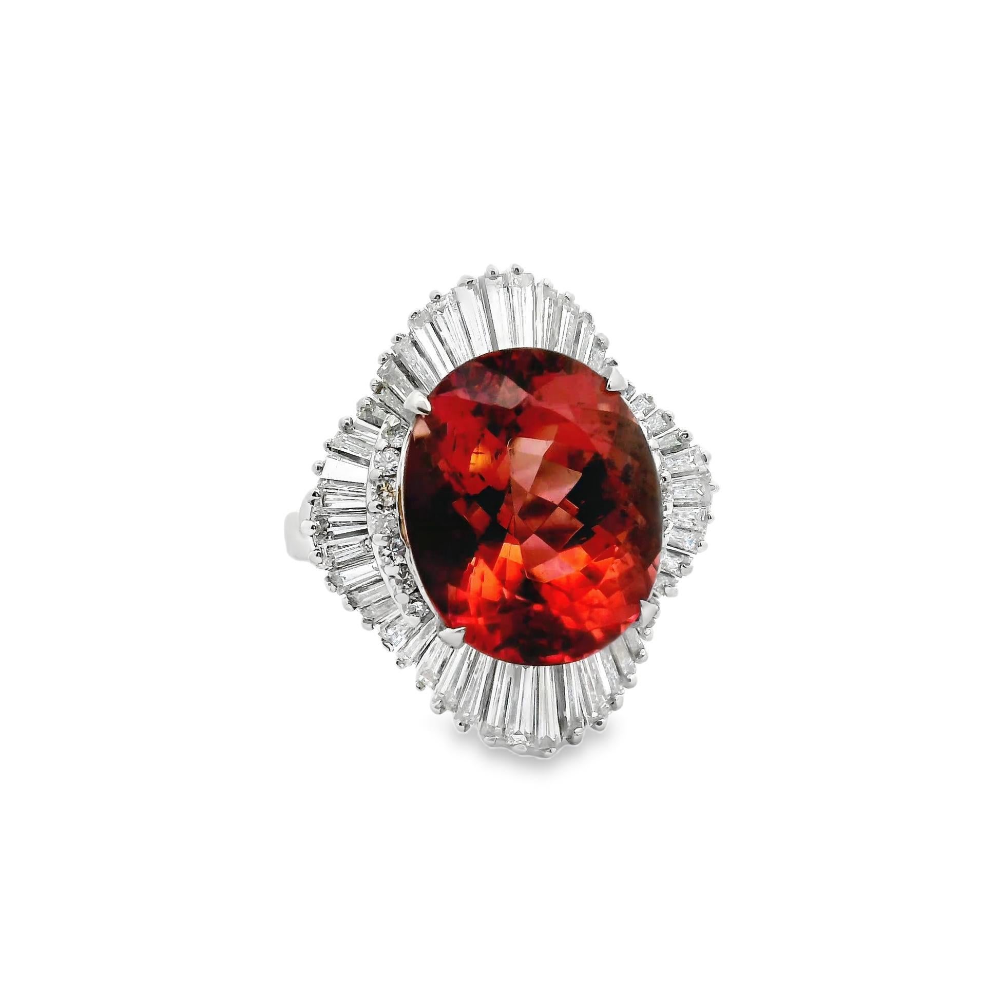 A chic and stylish ring featuring a large 10.46 carat oval-shape tourmaline. It has a rich and vibrant warm peach-color that compliments skin color. The ring is accented by 2.40 carats of baguette and round brilliant-cut diamonds which are set