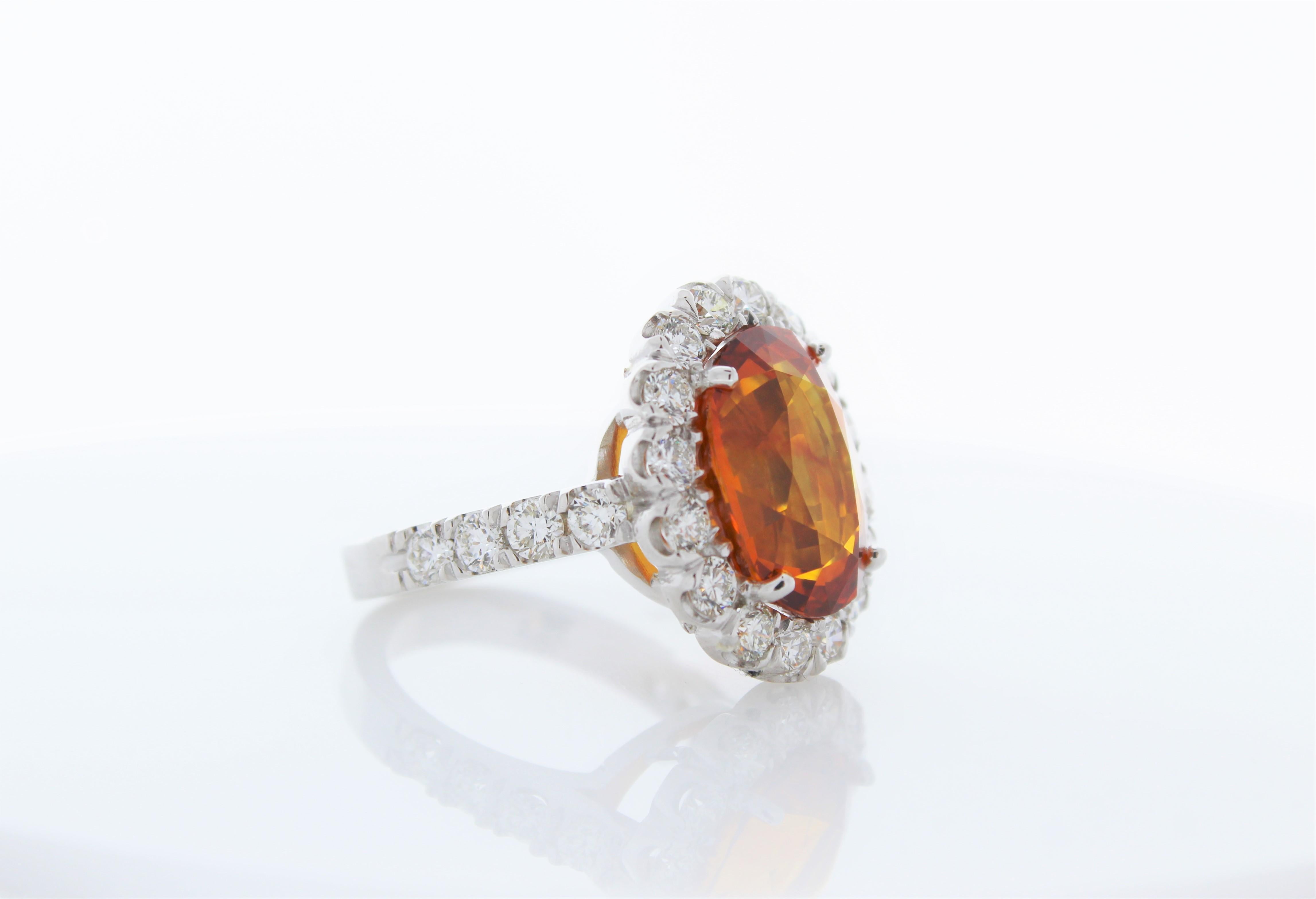Majestic and elegant, this stunning fashion gemstone ring is spectacular from start to finish. It features a richly saturated orangey 10.47 carat. The size of this orange sapphire is the stunner of the ring. A dazzling array of 1.98 carat round