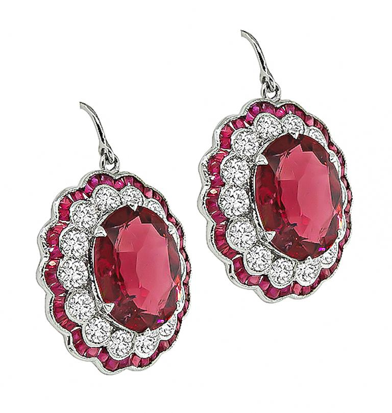 This is an elegant pair of 14k white gold earrings. The earrings feature lovely oval cut rubelites that weigh approximately 10.47ct. The rubelites are accentuated by sparkling round cut diamonds that weigh approximately 1.93ct. The color of these