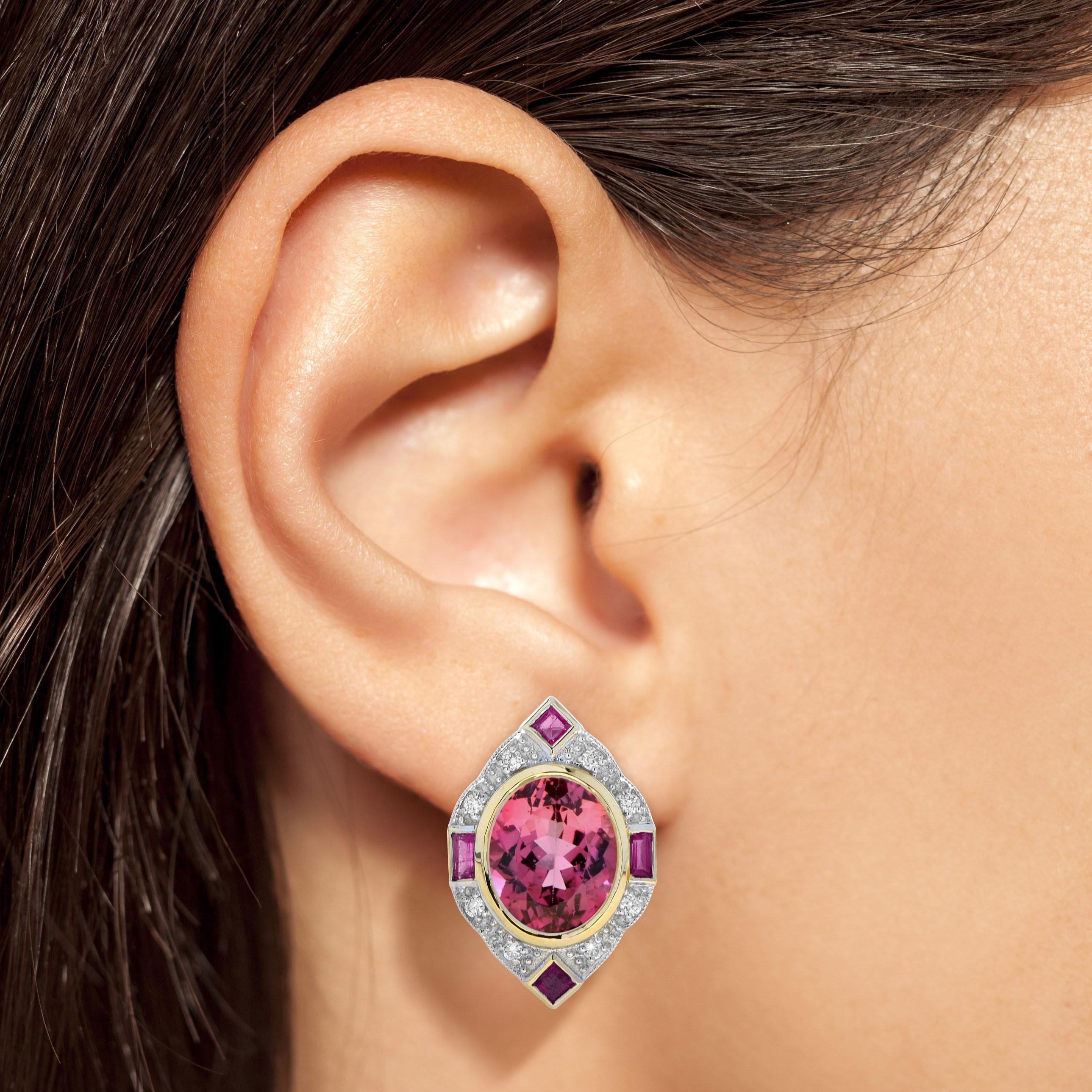 Crafted in 14k rose gold, this fanciful, Art Deco inspired earrings sees a raised an opulent total of 10.48 carat oval but bright pink tourmaline surrounded by sparkling round diamonds and rubies. This charming piece is a winsome adornment perfect