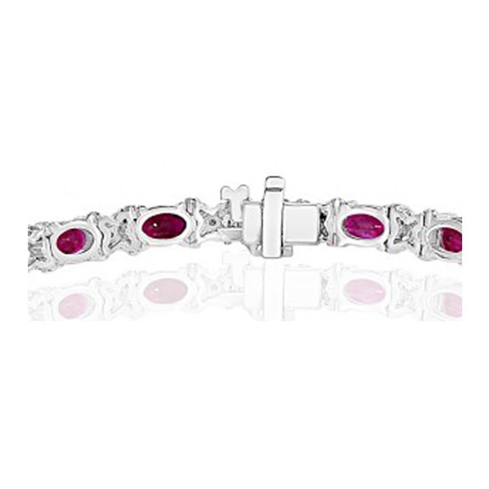 (18) Oval brilliant cut rubies accented with (90) round brilliant diamonds. The rubies are individually set with a diamond 'X' spacing the rubies. Set in 18kt white gold with a double safety catch.