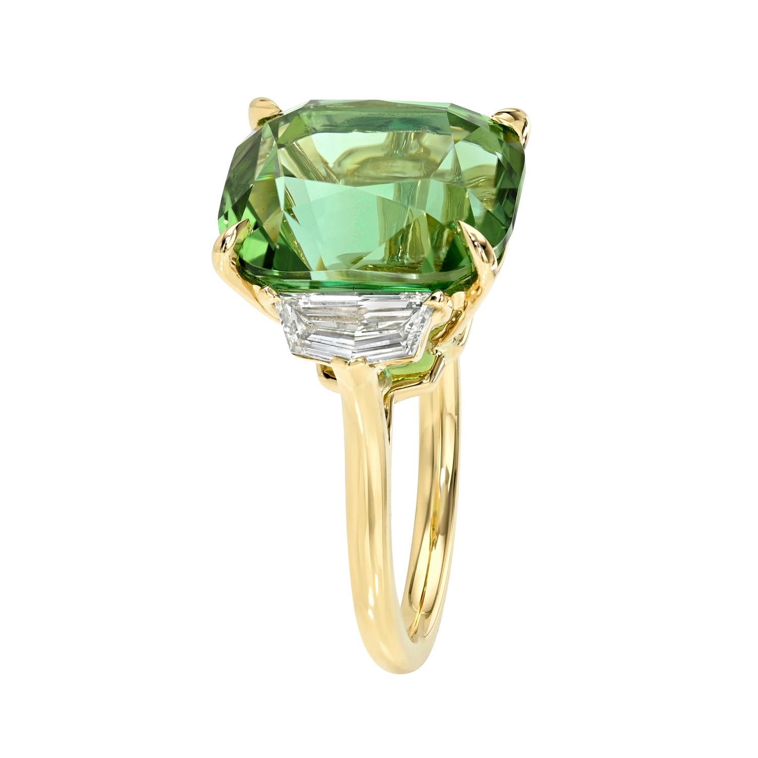 Cette bague à trois pierres unique en son genre présente une tourmaline néon menthe de 10,5 carats de taille coussin, sertie dans de l'or jaune 18 carats et rehaussée de deux diamants blancs de forme Cadillac de couleur E et de pureté VS1 totalisant