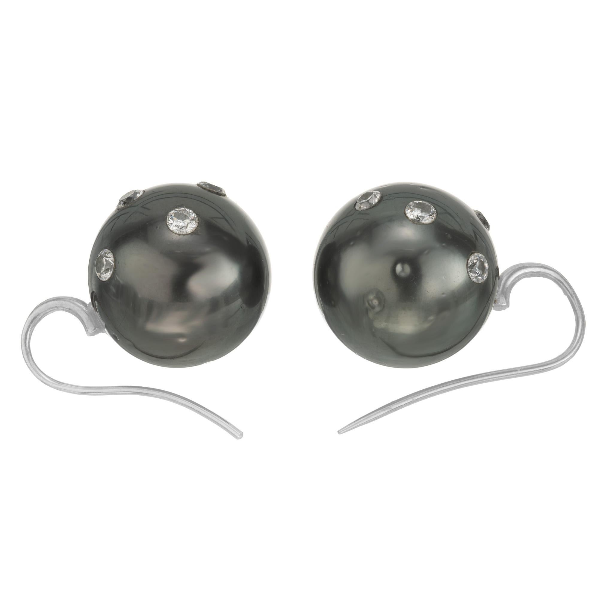 Two 16.3mm full size natural black South Sea cultured pearls. Drilled and set with 14 full-cut diamonds under 18k white gold antiqued earwires. These earrings offer a refined vintage touch, enhancing their modern yet classic allure. The luminous