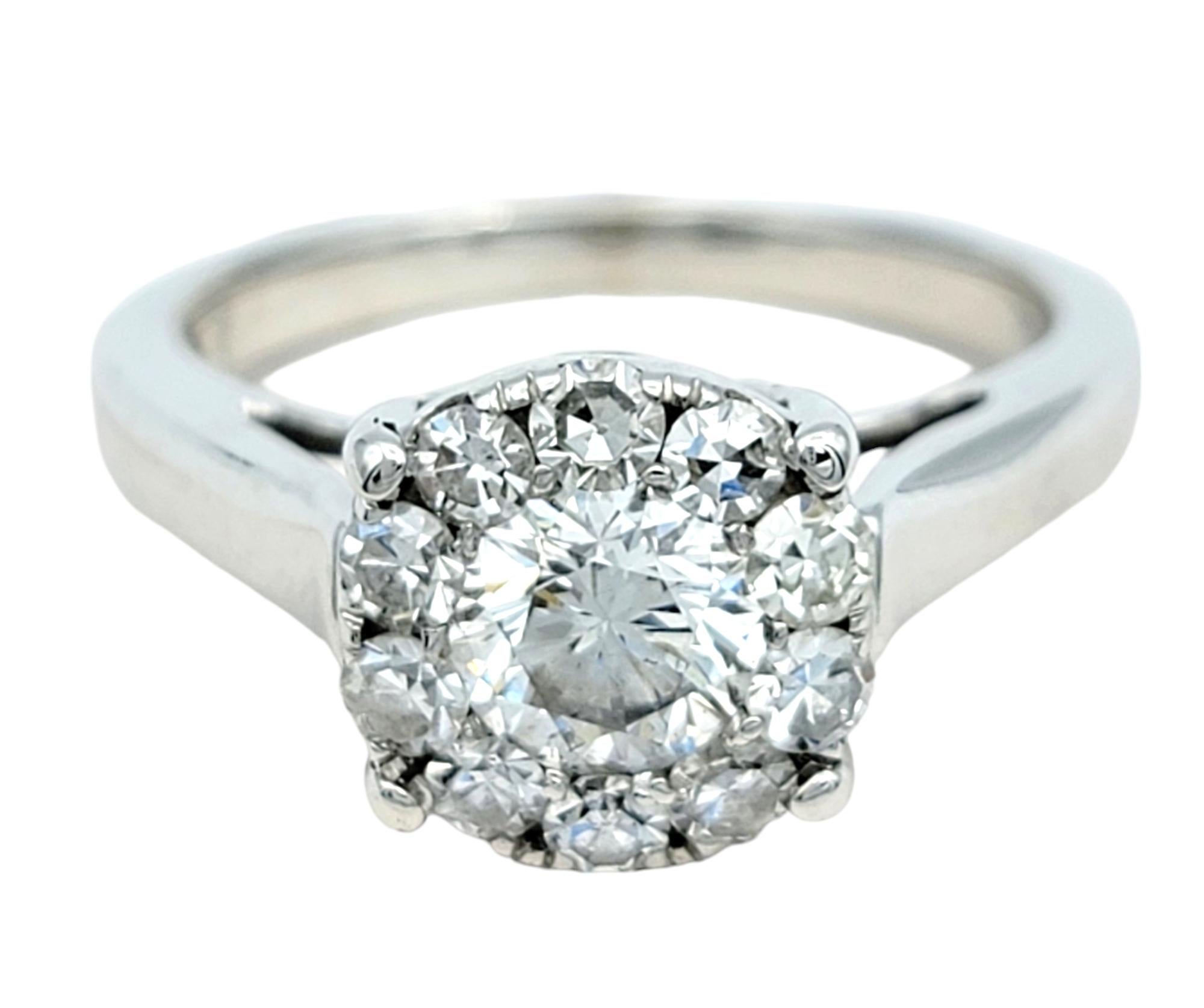 Ring Size: 5.75

Celebrate timeless romance with this enchanting engagement ring, a masterpiece of elegance and sparkle. At its heart, a brilliant .55 carat round brilliant diamond is nestled within a dazzling halo of smaller round diamonds,