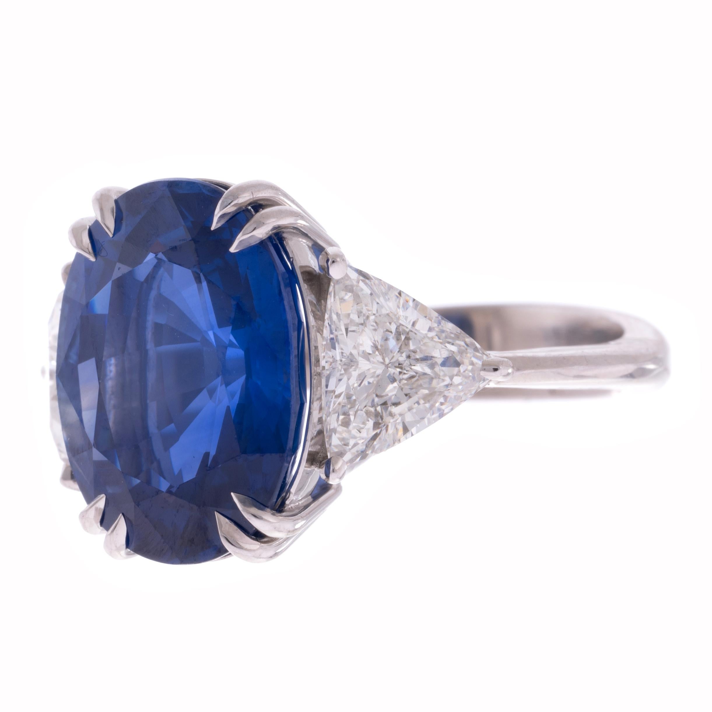 An absolute store favorite, we have an enchanting sapphire and diamond three-stone ring handmade in platinum. The rich blue hue and lively color of the featured Sapphire makes for a truly exceptional 10+ carat ring! Two stunning H color SI1 clarity