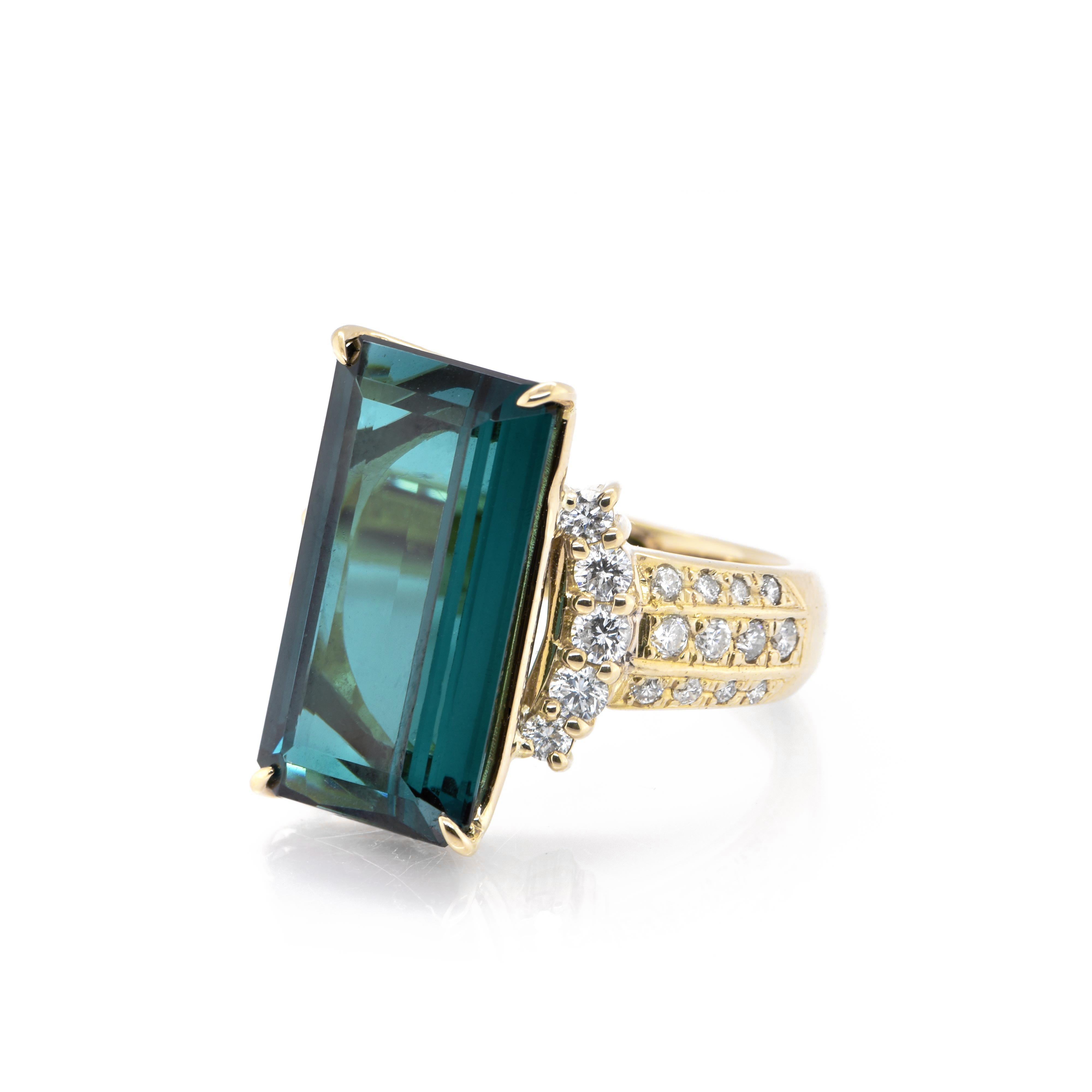 A stunning Cocktail Ring featuring a 10.56 Carat, Natural Indicolite Tourmaline and 1.00 Carats of Diamond Accents set in 18 Karat Yellow Gold. Tourmalines were first discovered by Spanish conquistadors in Brazil in 1500s. The name Tourmaline comes