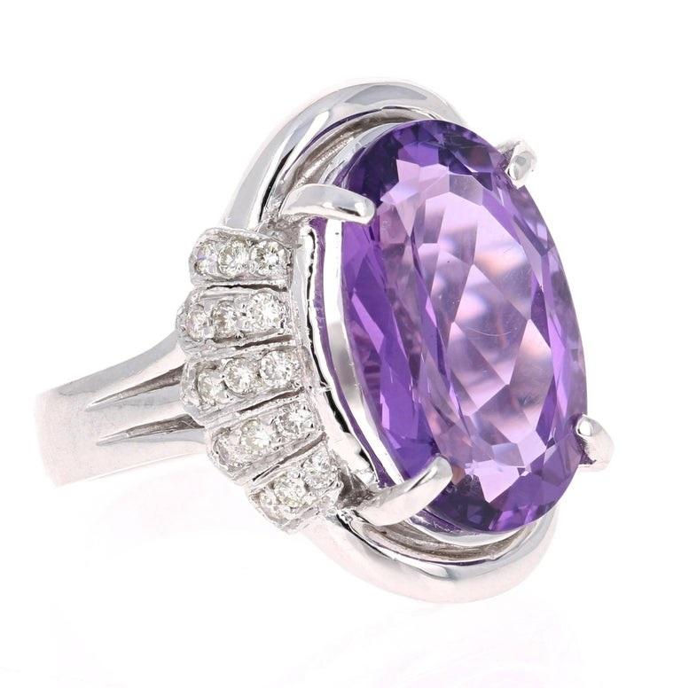 This beautiful ring has a 10.11 carat Oval Cut Amethyst set in the center and is surrounded by 30 Round Cut Diamonds that weigh 0.48 carats.  The total weight of the ring is 10.59 carats.  The ring is made in 14K White Gold and weighs approximately