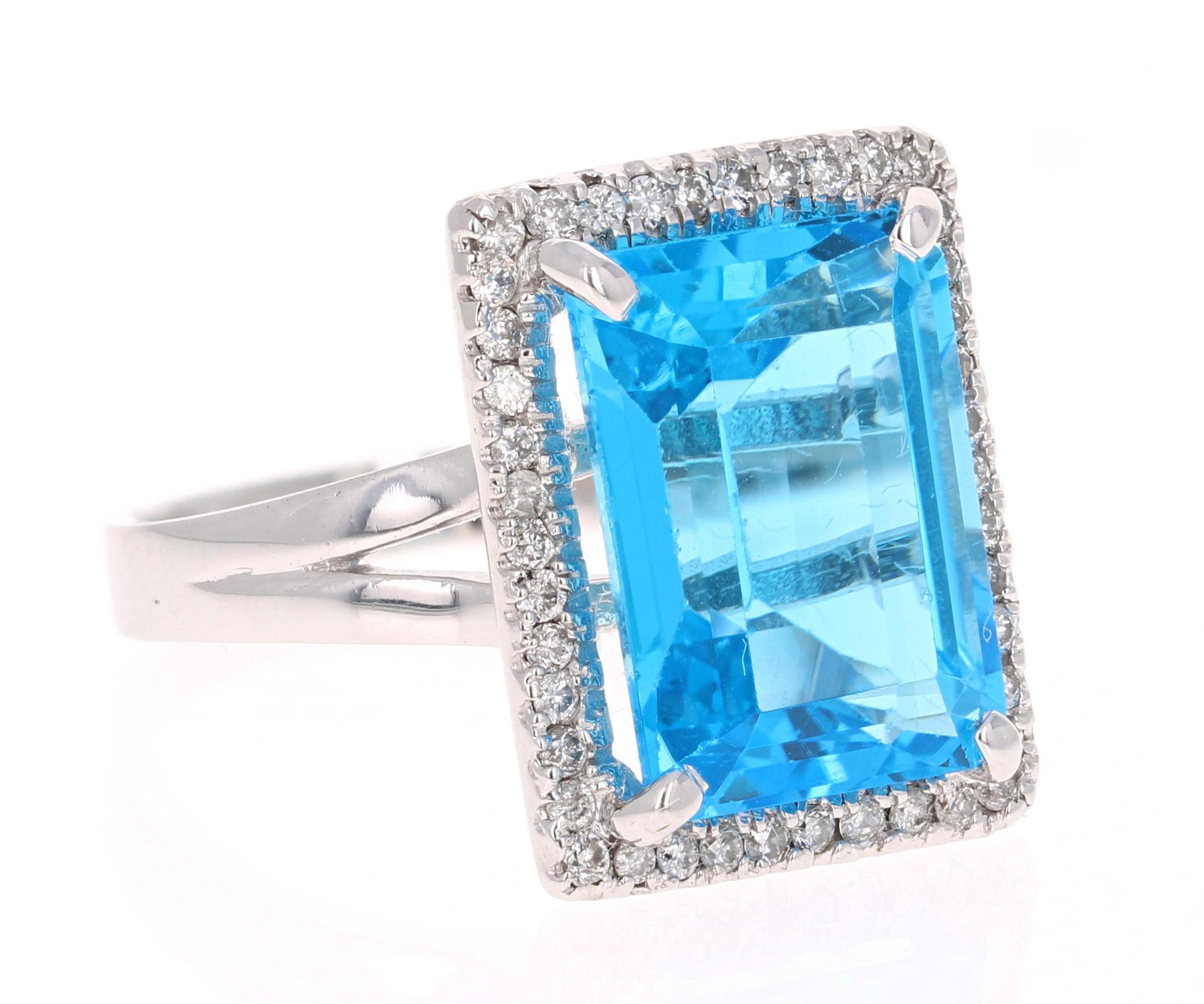 This stunning statement ring has a large Emerald Cut Blue Topaz that weighs 10.21 Carats. 
It is surrounded by a simple halo of 43 Round Cut Diamonds that weigh 0.38 Carats. 

It is crafted in 14 Karat White Gold and weighs approximately 5.5 grams.