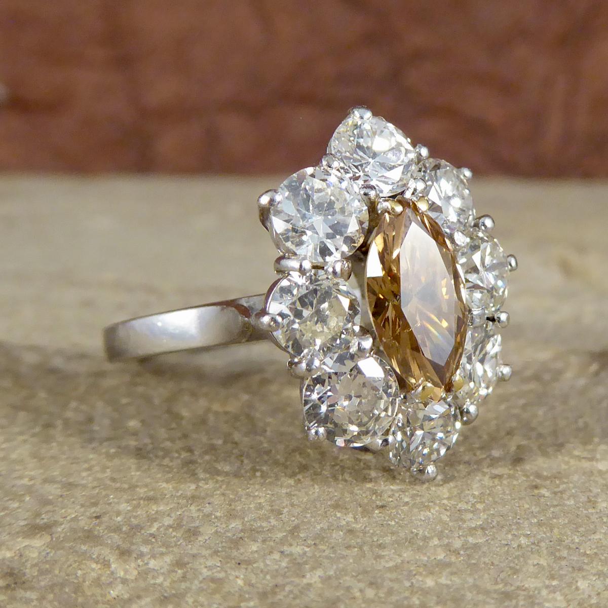 A beautiful mid to late 20th Century Cognac Brown Diamond and Diamond cluster ring. The Cognac Diamond is Marquise shaped with a Diamond surround with claw settings leading to a tapering White Gold shoulder into a plain 