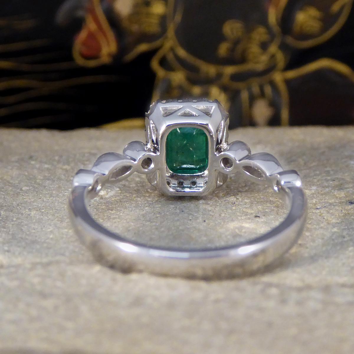 Emerald Cut 1.05ct Emerald and Diamond Cluster Ring with Diamond Shoulders in Platinum For Sale