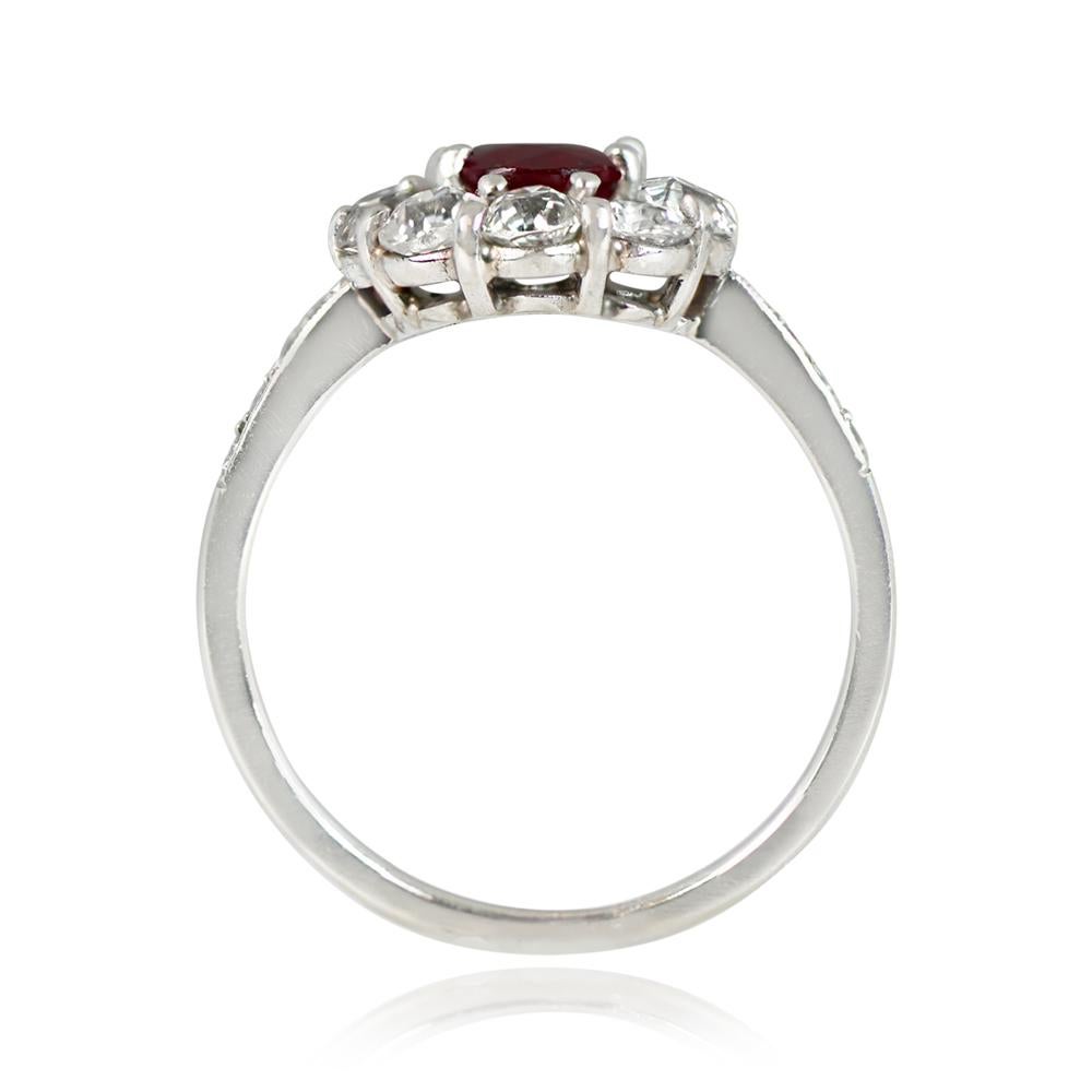 Edwardian-inspired ring featuring a 1.05-carat oval-cut natural ruby surrounded by a halo of old mine-cut diamonds in a floral head motif. Pave-set diamonds adorn the shoulders. The total diamond weight is around 1.50 carats. Crafted in platinum