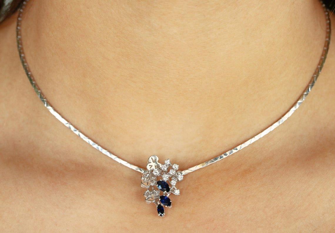 Beautifully crafted in luxurious 18K white gold, this piece features exquisite marquise sapphires that are set in a prong setting. The marquise sapphires have an royal blue color, strikingly clean eye clarity, and superb luster. White diamonds are