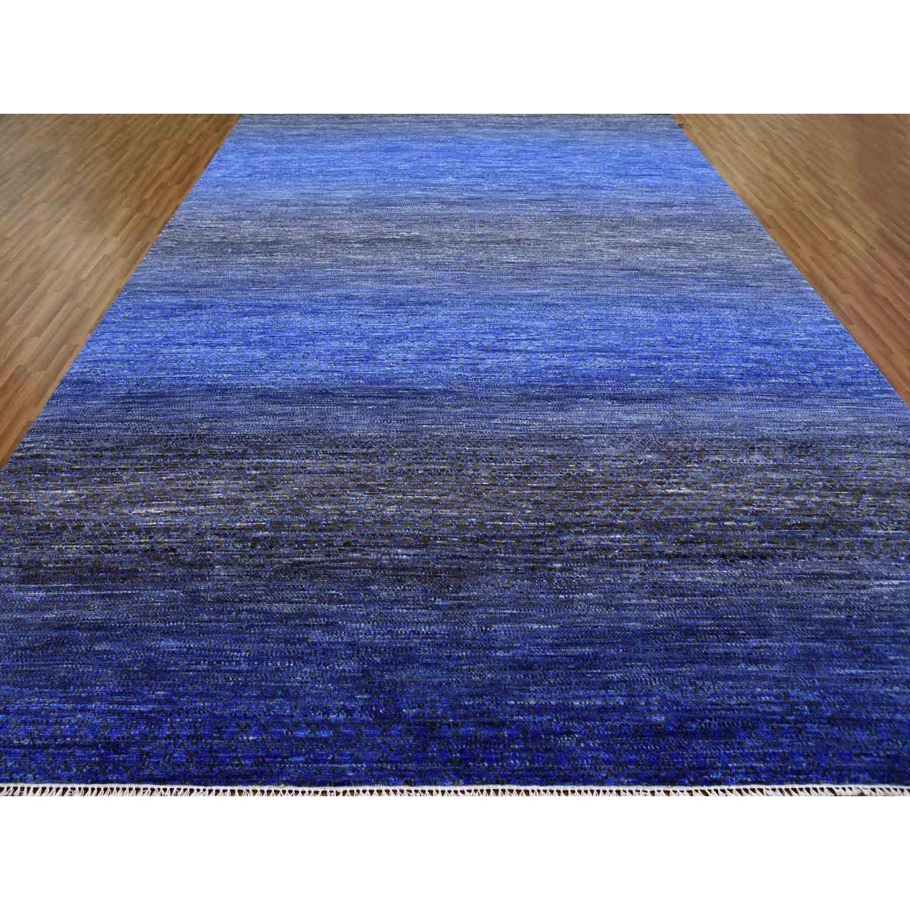 Il s'agit d'un véritable tapis oriental noué à la main, bleu denim, en pure laine, de la collection moderne Chiaroscuro, épais et pelucheux. Il a été noué pendant des mois et des mois selon des techniques de tissage séculaires par des artisans