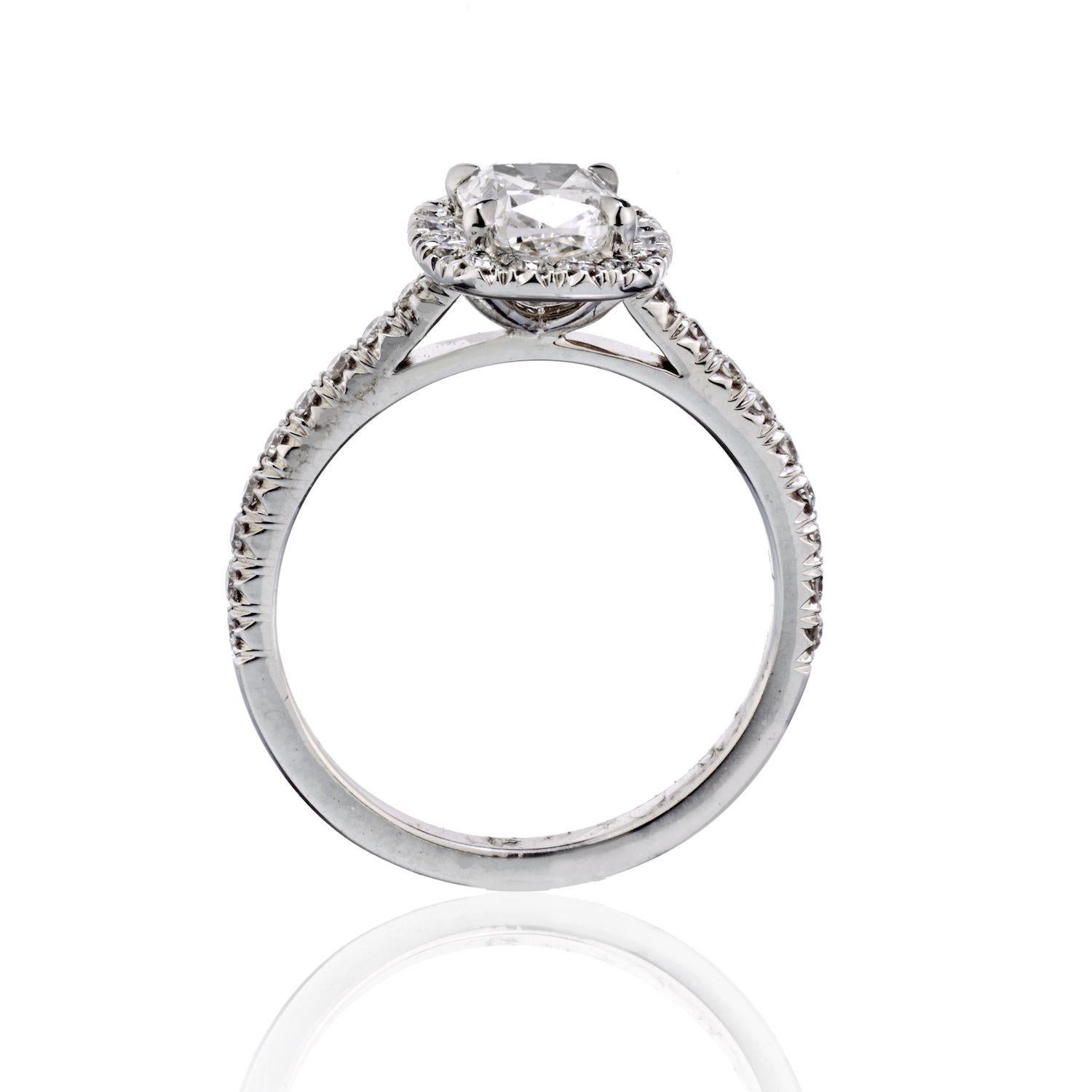 This lovely cushion cut halo set diamond engagement ring features 1.06 carat center dimaond in sparkly round brilliant diamond setting. Round cuts set around the center stone and along the ring's shank. Four prongs securely hold your center stone,