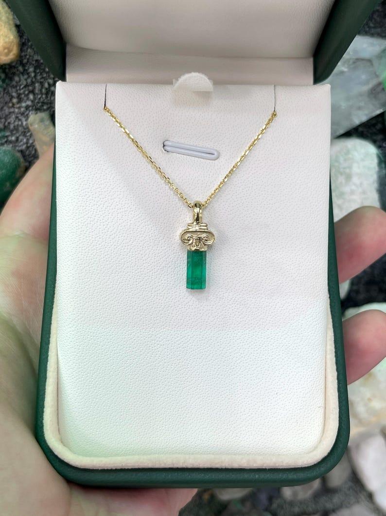 Introducing our Natural Rough Emerald Pendant, a distinctive and unisex statement piece showcasing the raw beauty of a 1.06-carat terminated emerald crystal from the verdant landscapes of Colombia. The untamed, rough-cut crystal, with its vivid