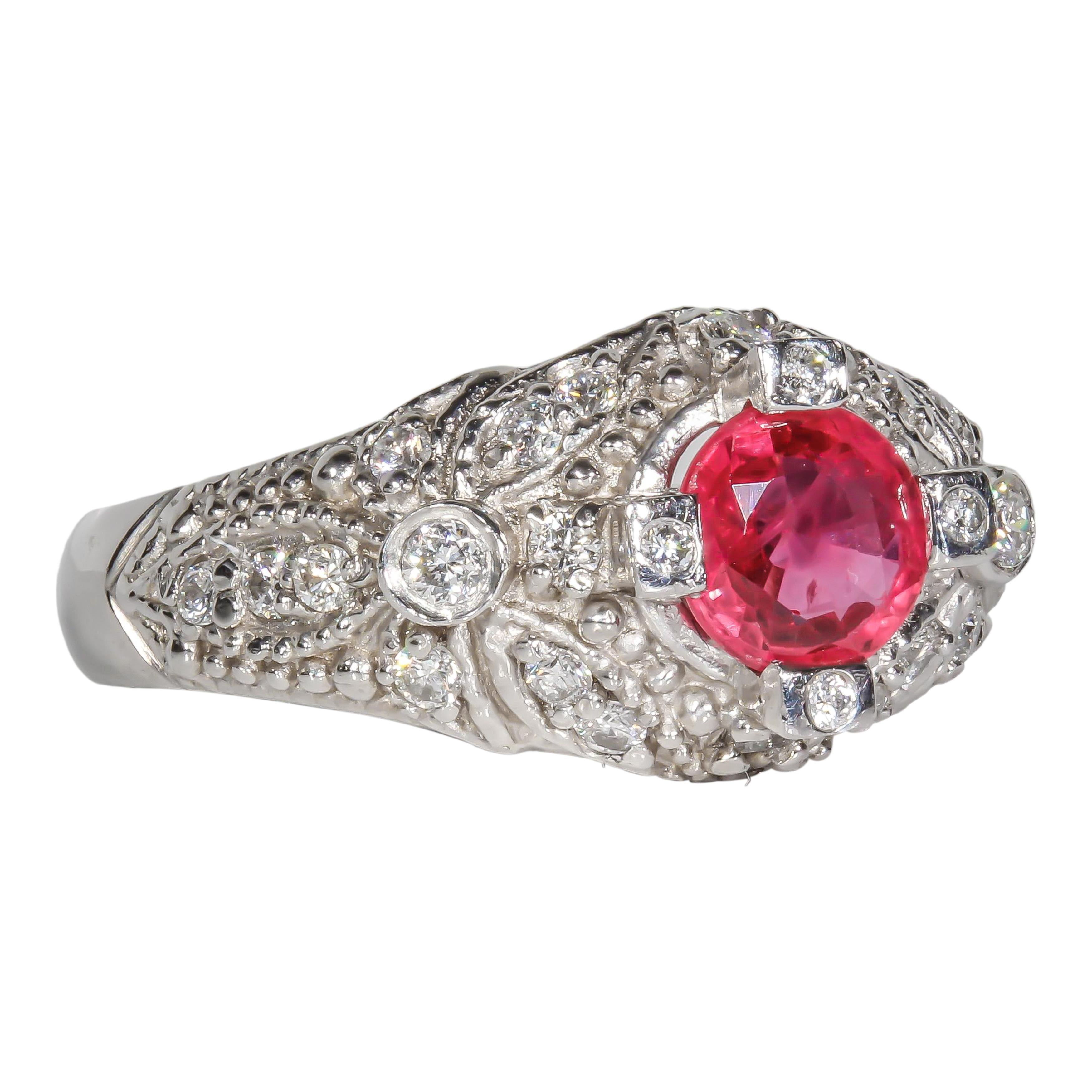 Platinum cocktail ring containing a 1.06 carat ruby center stone with round brilliant natural diamond side stones. The total weight of the 25 diamond side stones is 0.41 carats; additionally, the side stones have been graded internally as H-I color,