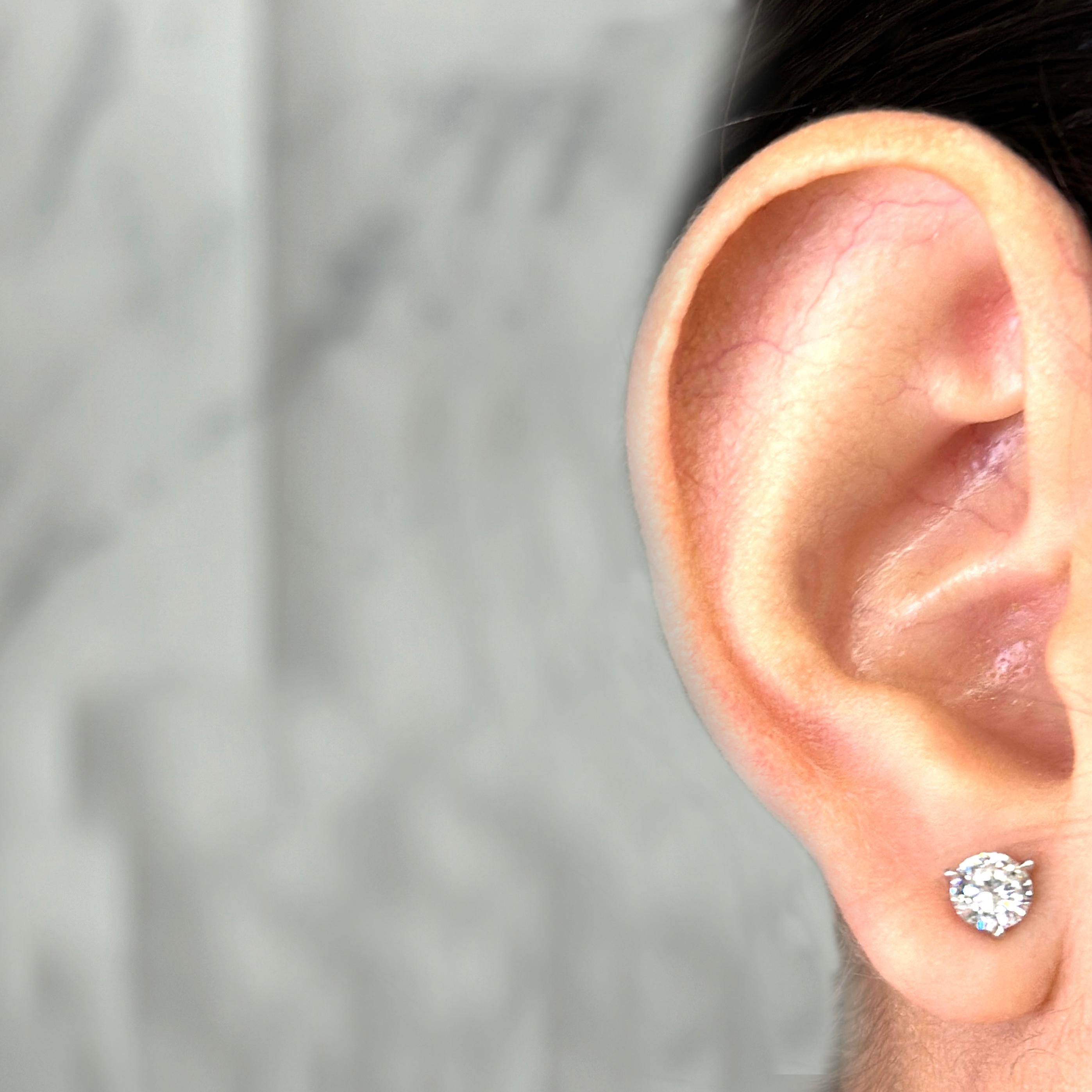 14 Karat White Gold Diamond Stud Earrings Featuring 2 Round Brilliant Cut Diamonds of F Color and SI Clarity Totaling 1.06 Carats. Three Prong Setting with Pierced Post and Friction Back.