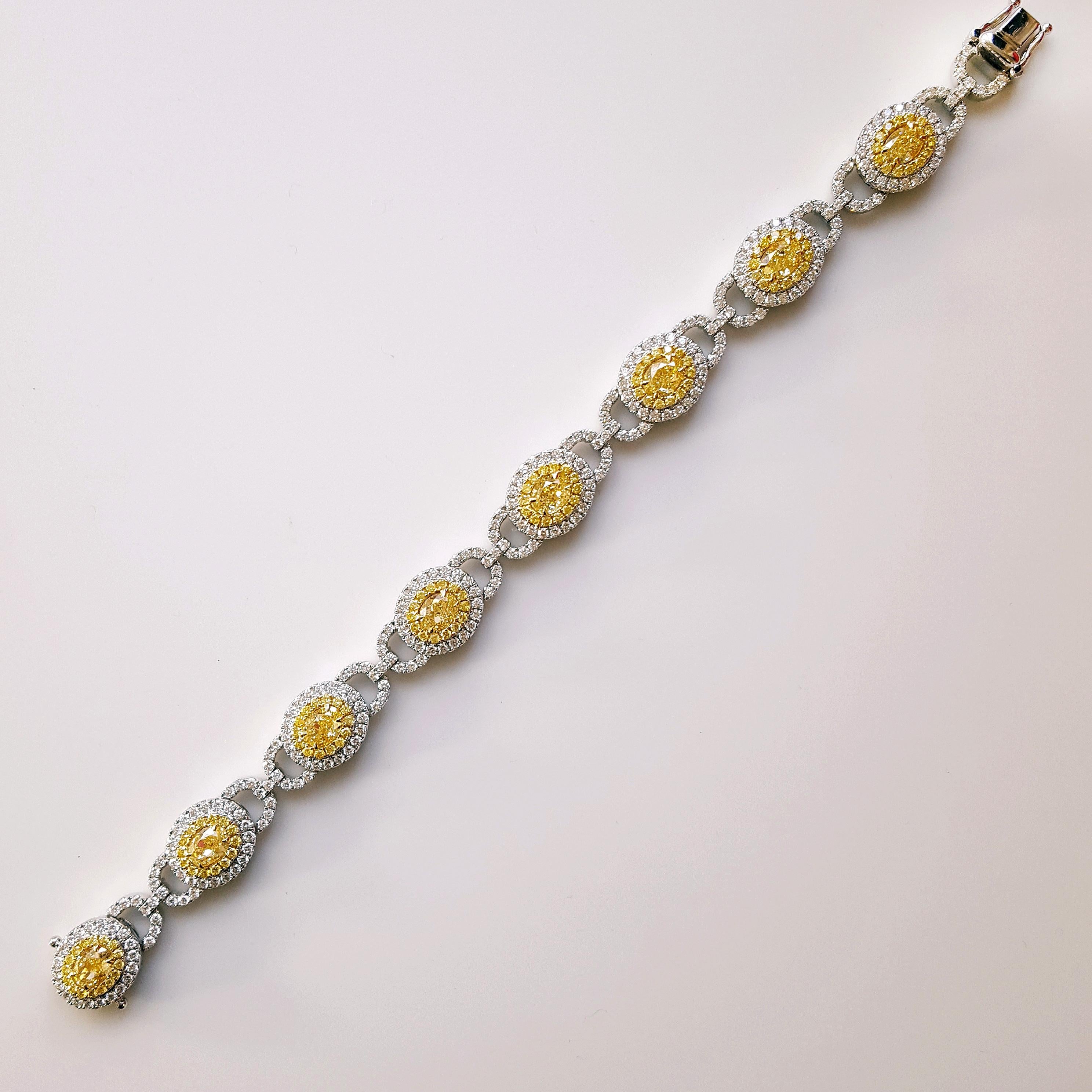 A truly remarkable statement bracelet featuring a dazzling array of of 8 Oval-Cut yellow diamonds at its heart weighing 5.59 carat total. Each of these exquisite yellow diamonds is cradled within 18K yellow gold and 18K white gold frames, adorned