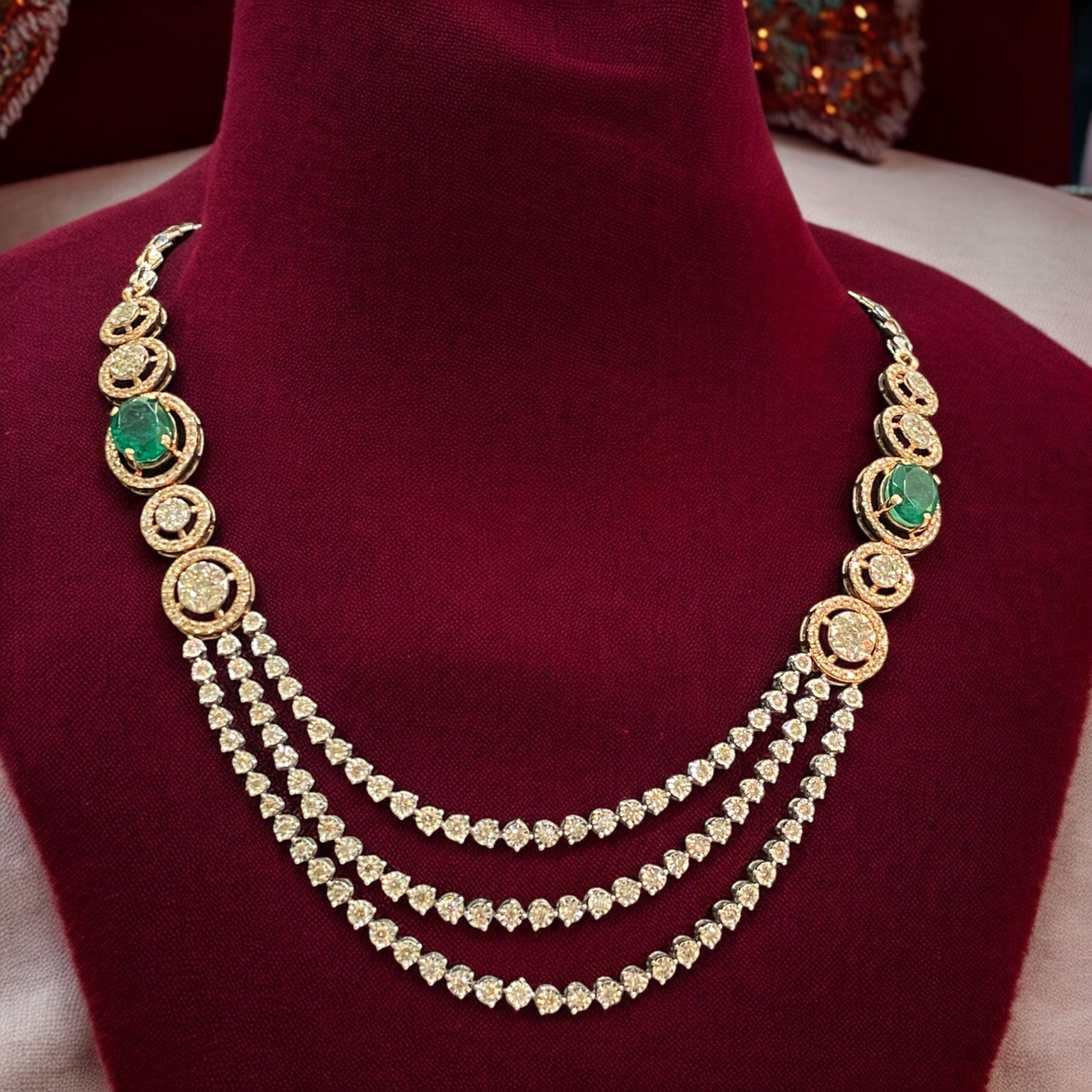 Experimenta el glamour en estado puro con este exquisito collar de tres vueltas con un diamante redondo talla brillante de 5,10 quilates y una esmeralda de 5,50 quilates en oro bicolor de 14 quilates. Regálate esta impresionante pieza, ¡diseñada