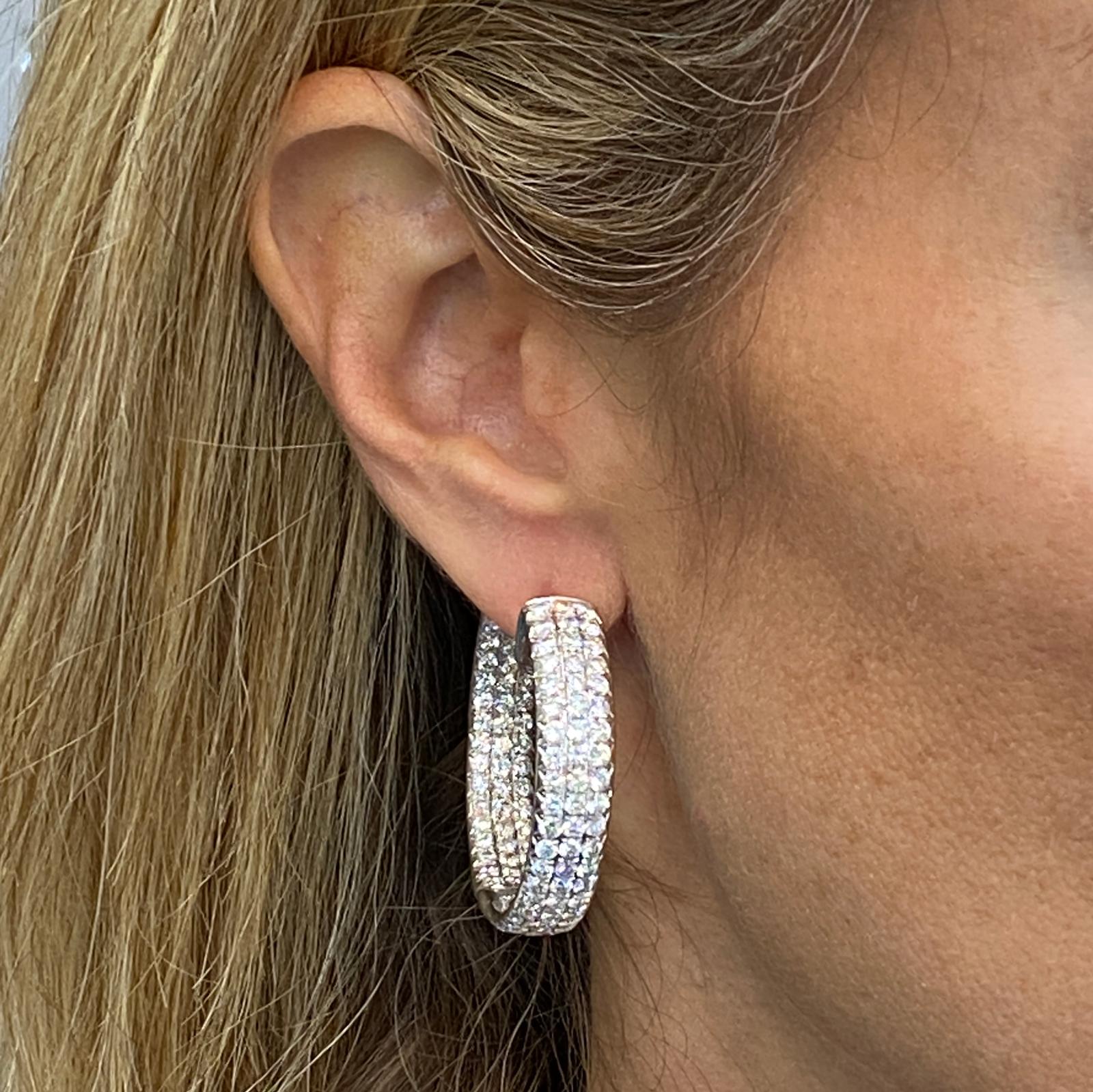 Stunning wide in & out diamond hoop earrings crafted in 18 karat white gold. The three rows feature 252 round brilliant cut diamonds weighing 10.65 carat total weight and graded F-G color and VS clarity. The hoops measure .30 inches in width, and