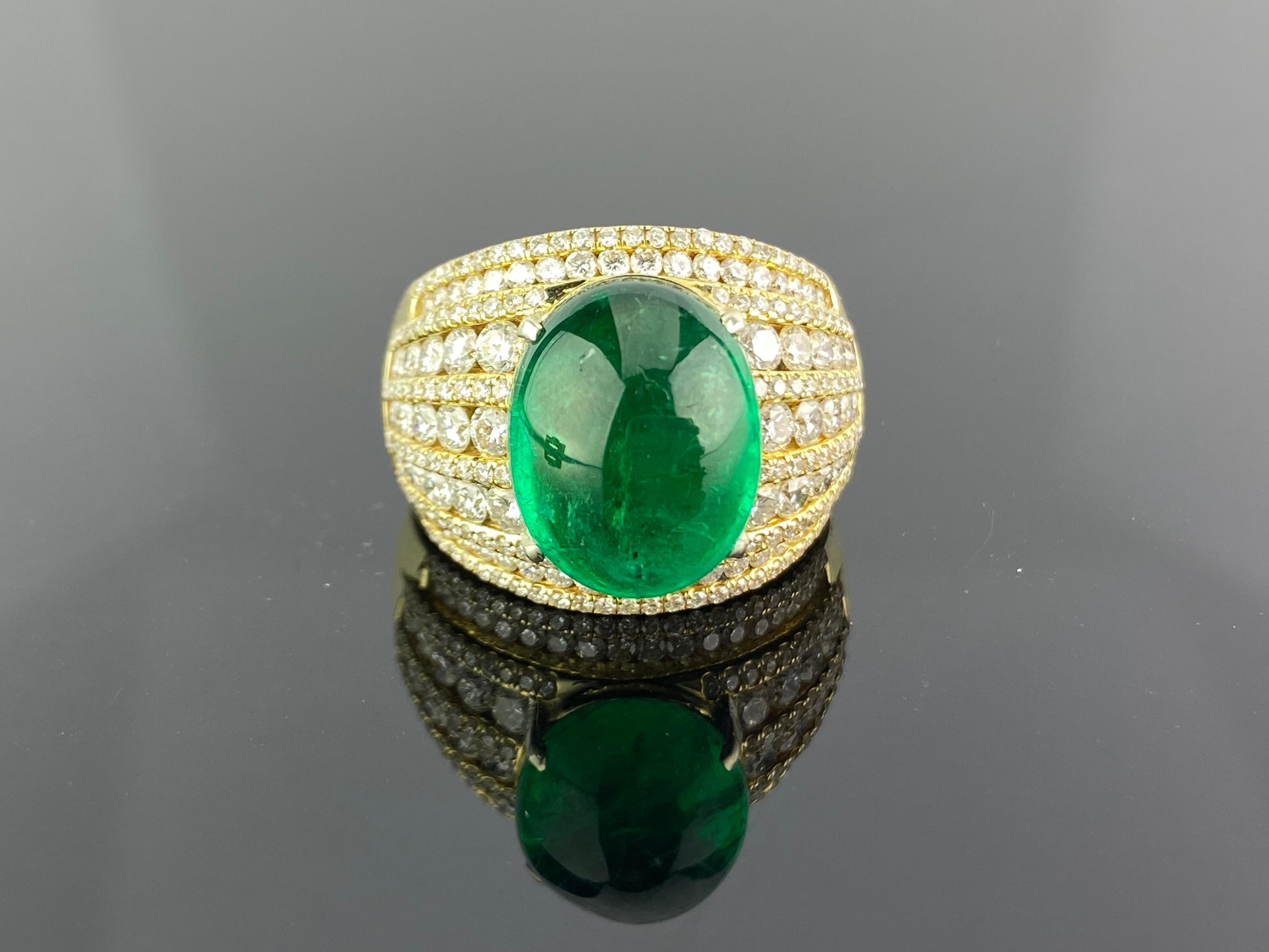 A 10.66 carat Zambian Emerald Cabochon ring with Diamonds all set in 18K yellow gold. The centre stone is completely transparent, with great lustre and colour Currently a ring size US 8.5, but we can resize the ring without additional cost.