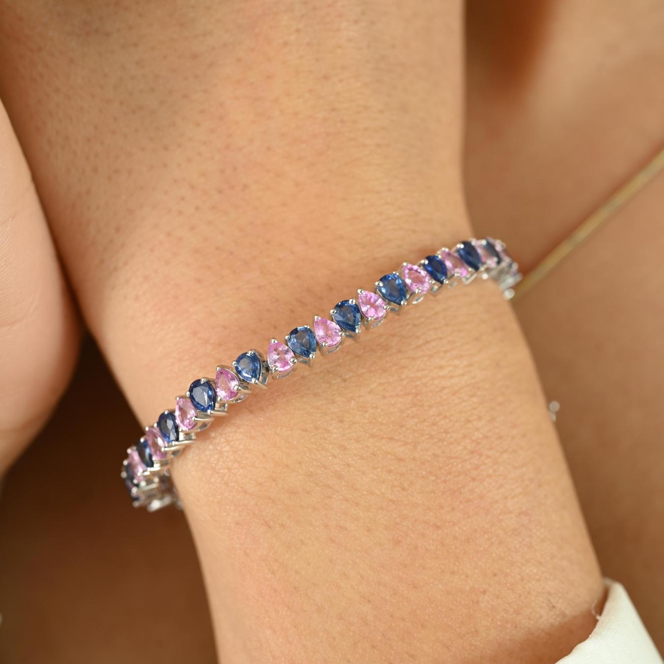 Add a touch of color and sophistication to your wrist with this stunning bracelet crafted in 18K white gold. Featuring a captivating alternation of pink and blue pear-shaped sapphires, the bracelet boasts a total stone weight of 10.68 carats. Each