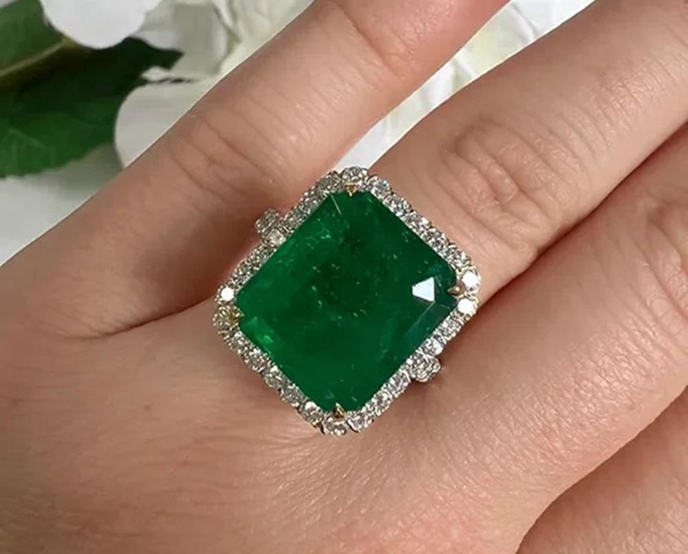 Emerald Weight: 10.68 CTS, Measurements: 14.7 x 12.8 mm, Diamond Weight: 1.13 CTS, Metal: 18K White Gold (Yellow Gold Basket), Ring Size: 7, Shape: Emerald-Cut, Color: Green, Hardness: 7.5-8, Birthstone: May, CD Certified