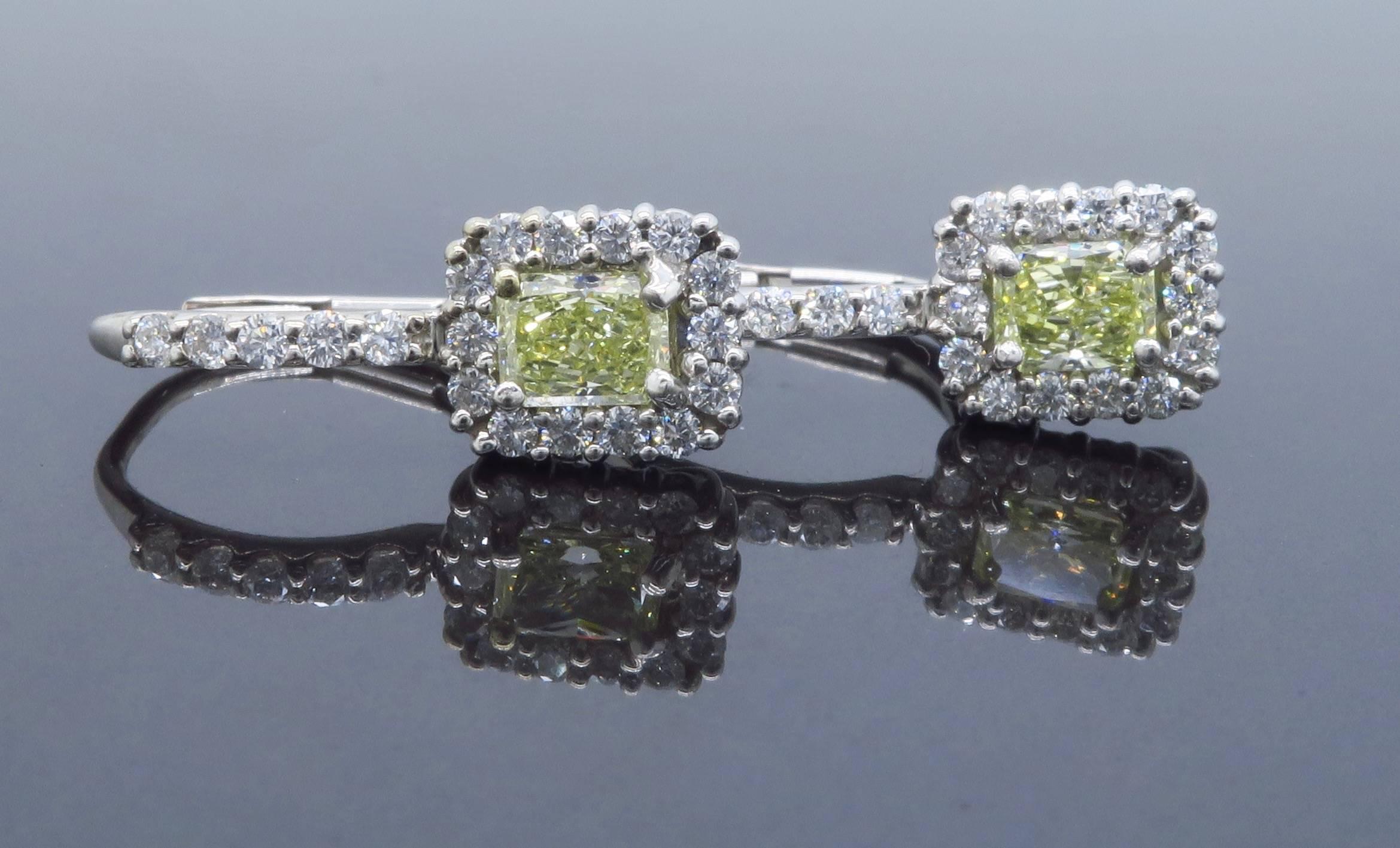 These gorgeous earrings feature two approximately .30CT Radiant Cut Diamonds, the featured diamonds are yellow in color and display VS clarity. There are 19 additional Round Brilliant Cut Diamonds surrounding each featured diamond. There is