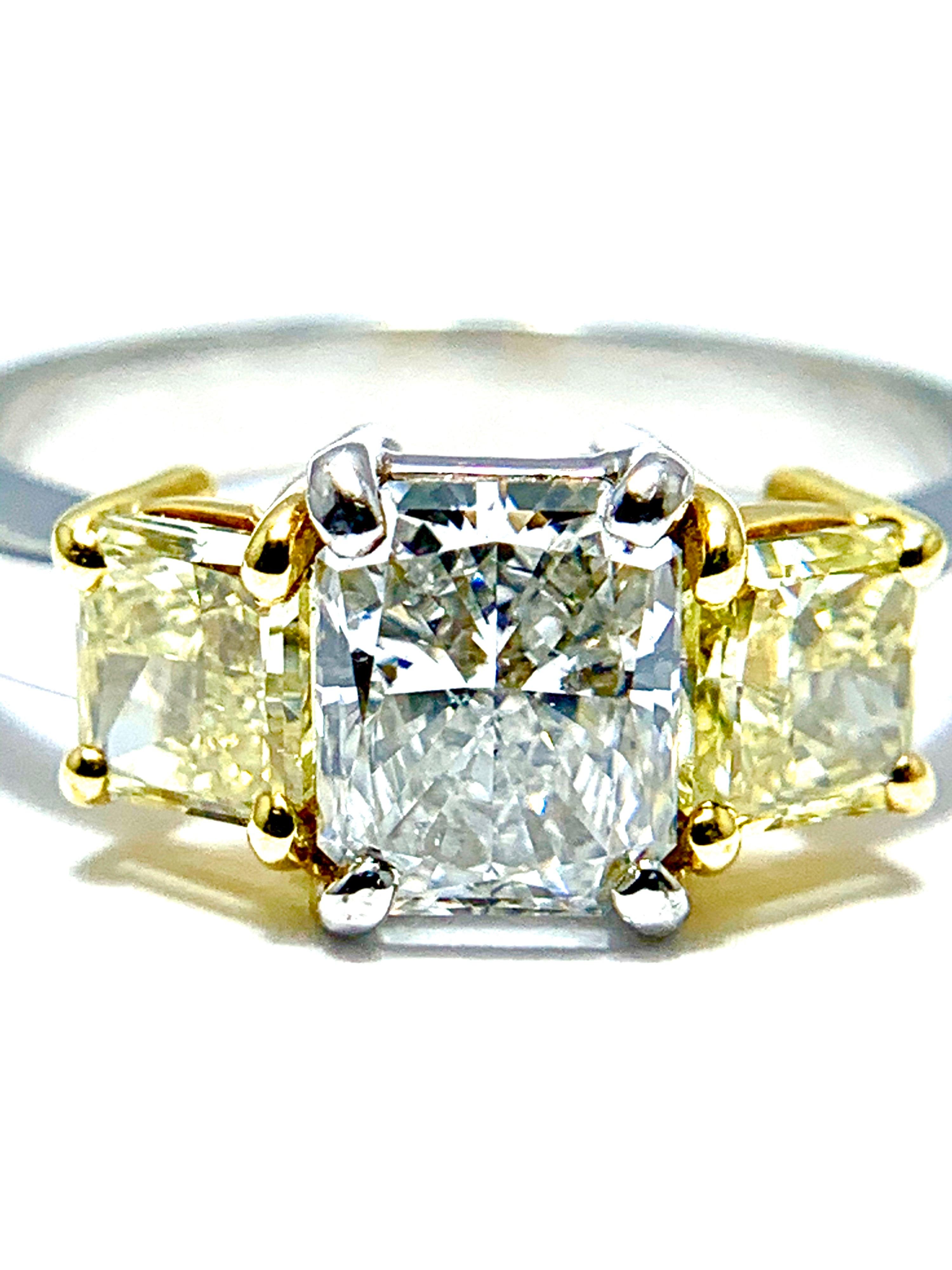 An absolutely stunning three diamond ring.  The center Diamond is a 1.07 carat radiant cut, graded by GIA as a I color, VS2, flanked on either side by two fancy yellow radiant cut Diamonds weighing 0.70 carats total.  The two yellow Diamonds are set