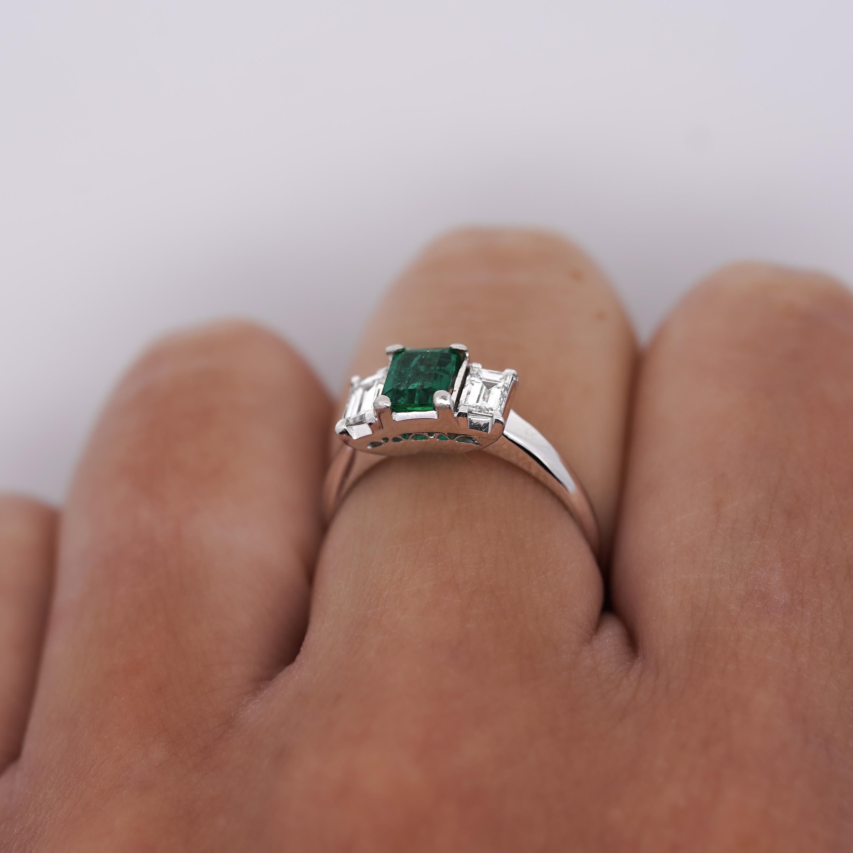 0.57 Carat Emerald-Cut Natural Green Emerald with Emerald-Cut Diamond Side Stones in Platinum 850 Three-Stone Engagement Ring. Thin, dainty, and full of life. 

Details: 
Item Type: Women's Ring
Metal: Platinum 850
Size: US 6.5
Weight: 3.83