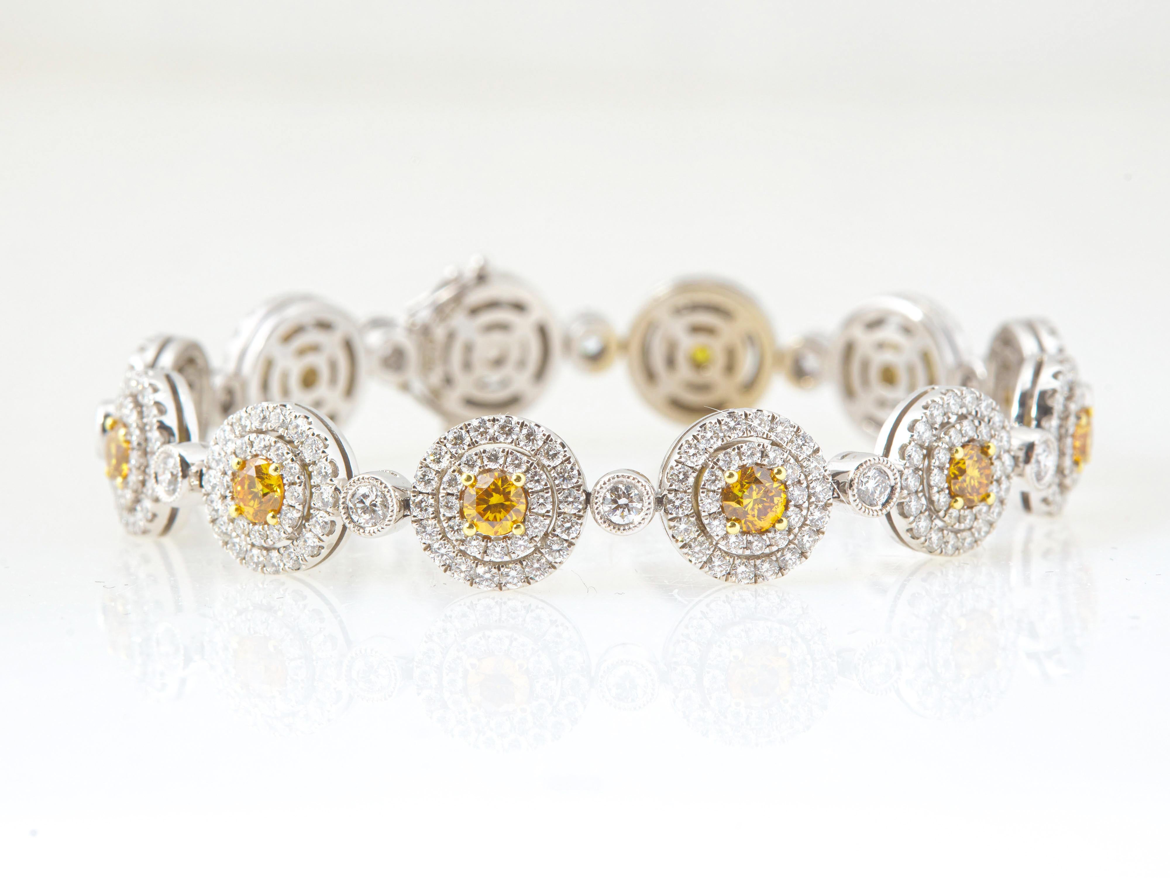 A stunning 10.74 carat Round Brilliant Fancy Vivid-Intense Orange-Yellow diamond halo bracelet, featuring 2.92 fancy vivid-Intense yellow diamonds set in prongs, GIA certified. The diamonds are accented with 360 round brilliant white diamonds at