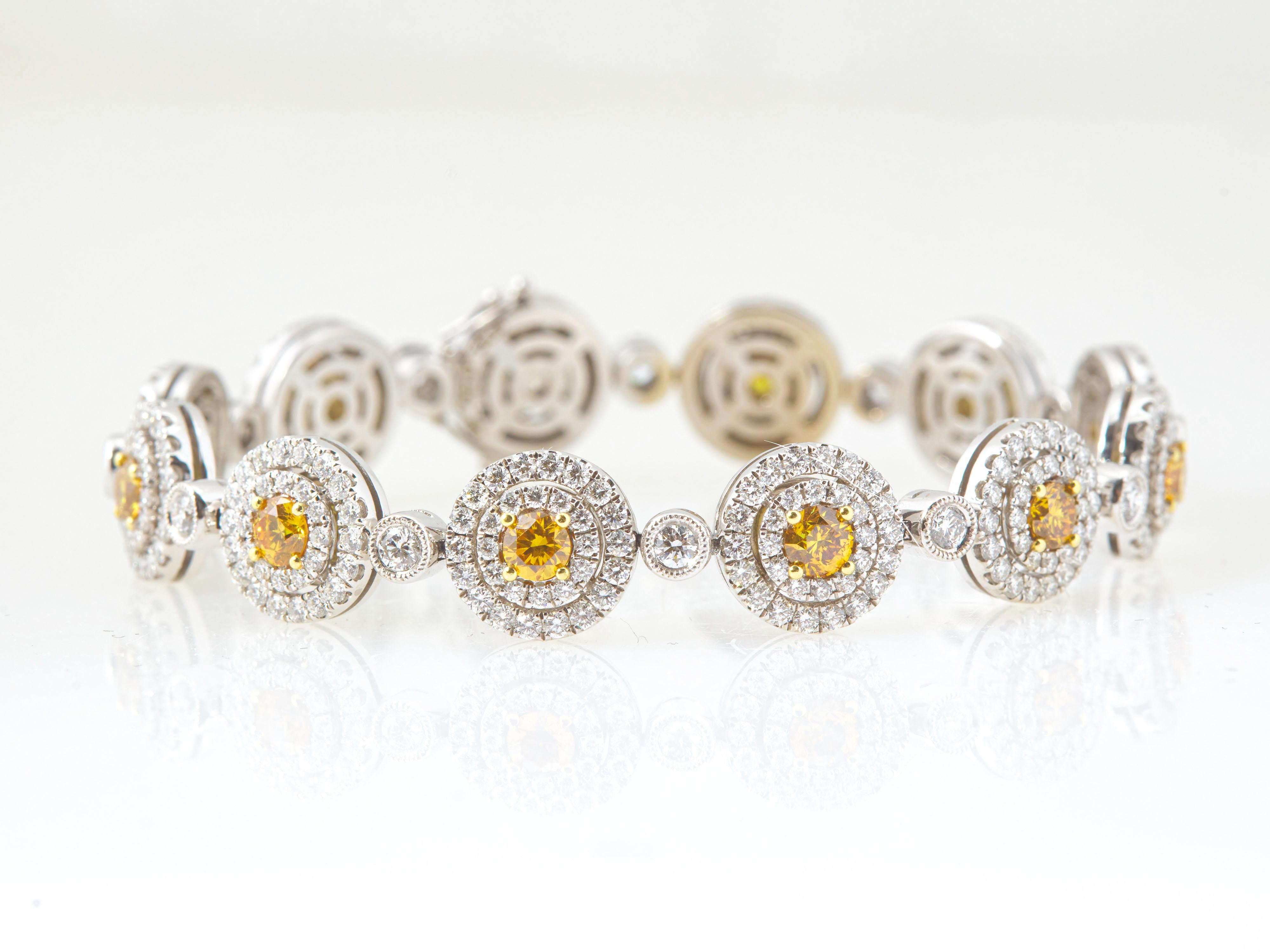 A stunning 10.74 carat Round Brilliant Fancy Vivid-Intense Orange-Yellow natural diamond halo bracelet, featuring 2.92 fancy vivid-Intense yellow diamonds set in prongs, GIA certified. The diamonds are accented with 360 round brilliant white