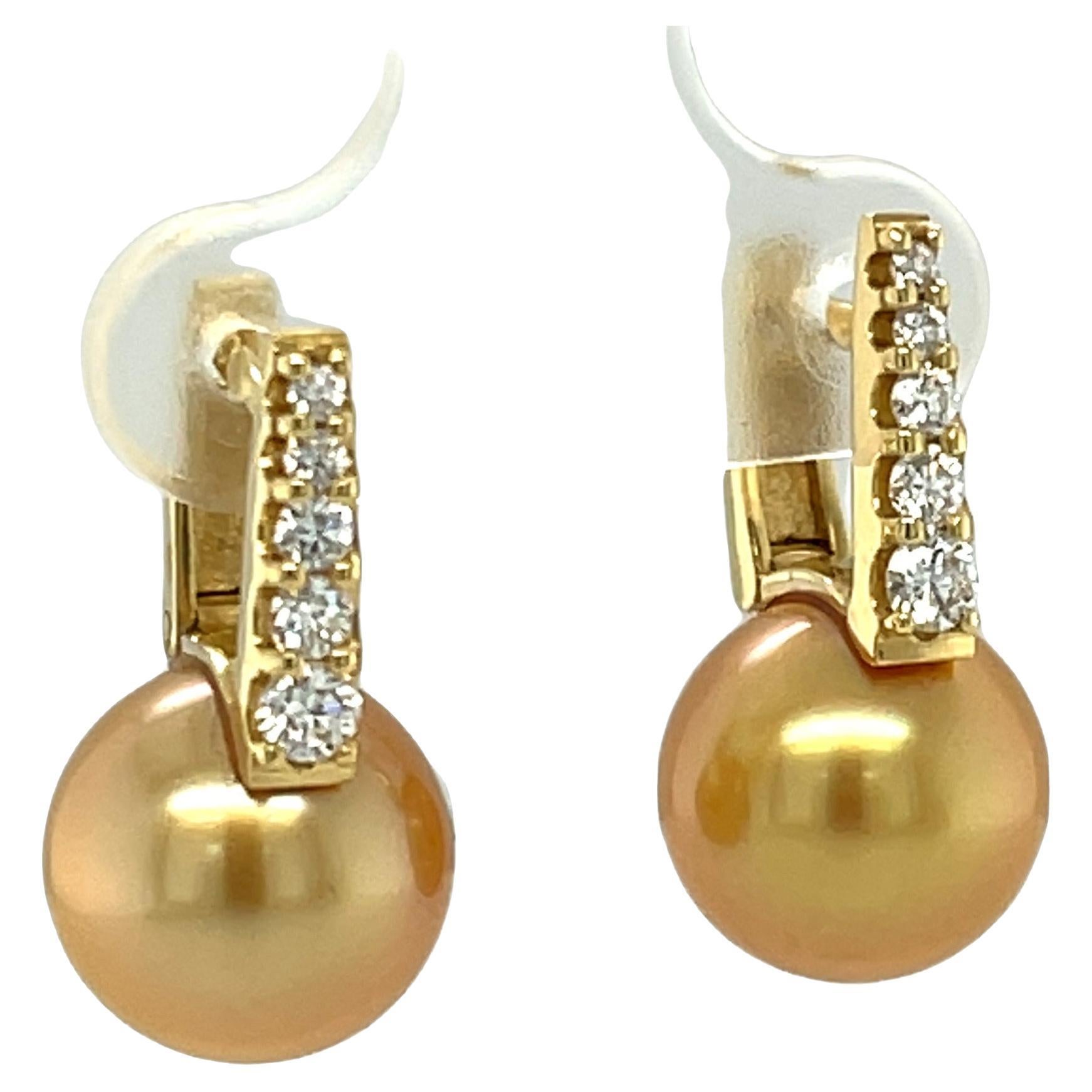 These beautiful drop earrings feature large, 10.75mm round South Seas pearls that are highly lusterous and have breathtaking golden color! The pearls are suspended from sparkling 18k yellow gold bars set with brilliant white diamonds in graduating