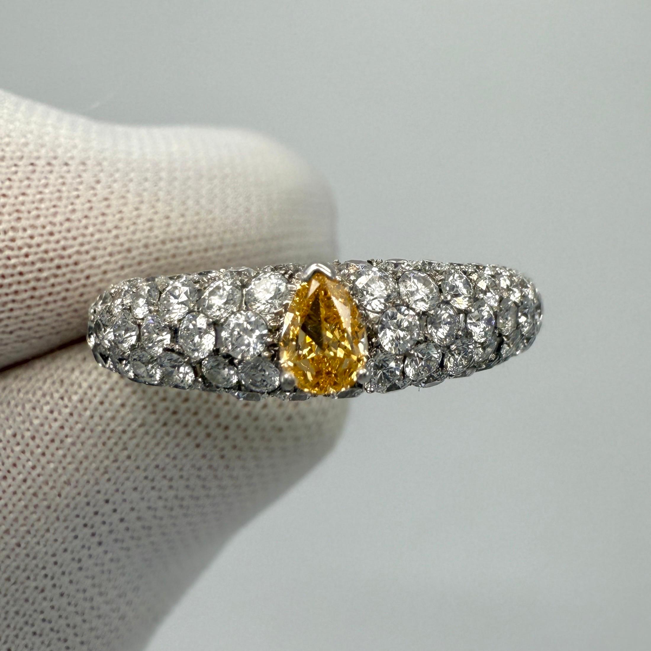 Natural Pear Cut Fancy Vivid Orange Yellow & Pave White Diamond 18k White Gold Band Ring. 1.07 Total carat.

Stunning 0.143ct (marked) fancy vivid orange yellow untreated diamond set in a beautiful 18k white gold band ring. Accented by 0.927ct
