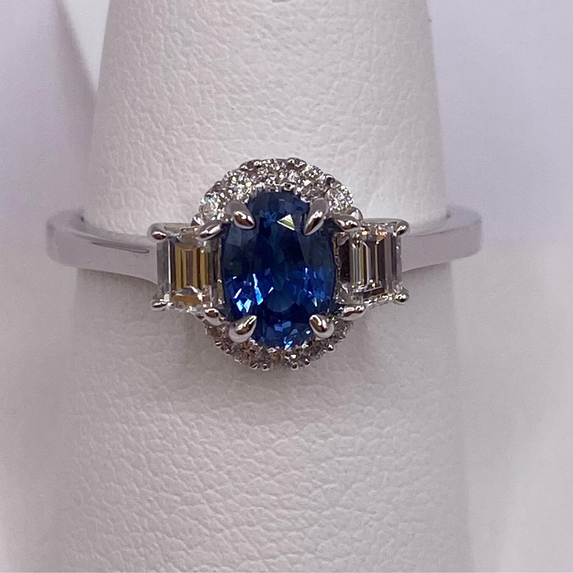 18KT White Gold
Ring Size: 6.50
Band: 1.6mm Wide
(ring is size 6.5 but is sizable upon request)

Number of Oval Sapphires: 1
Carat Weight: 0.68ct
Stone Size: 6.5 x 4.5mm
Color: Cornflower Blue

Number of Trapezoid Diamonds: 2
Carat Weight: