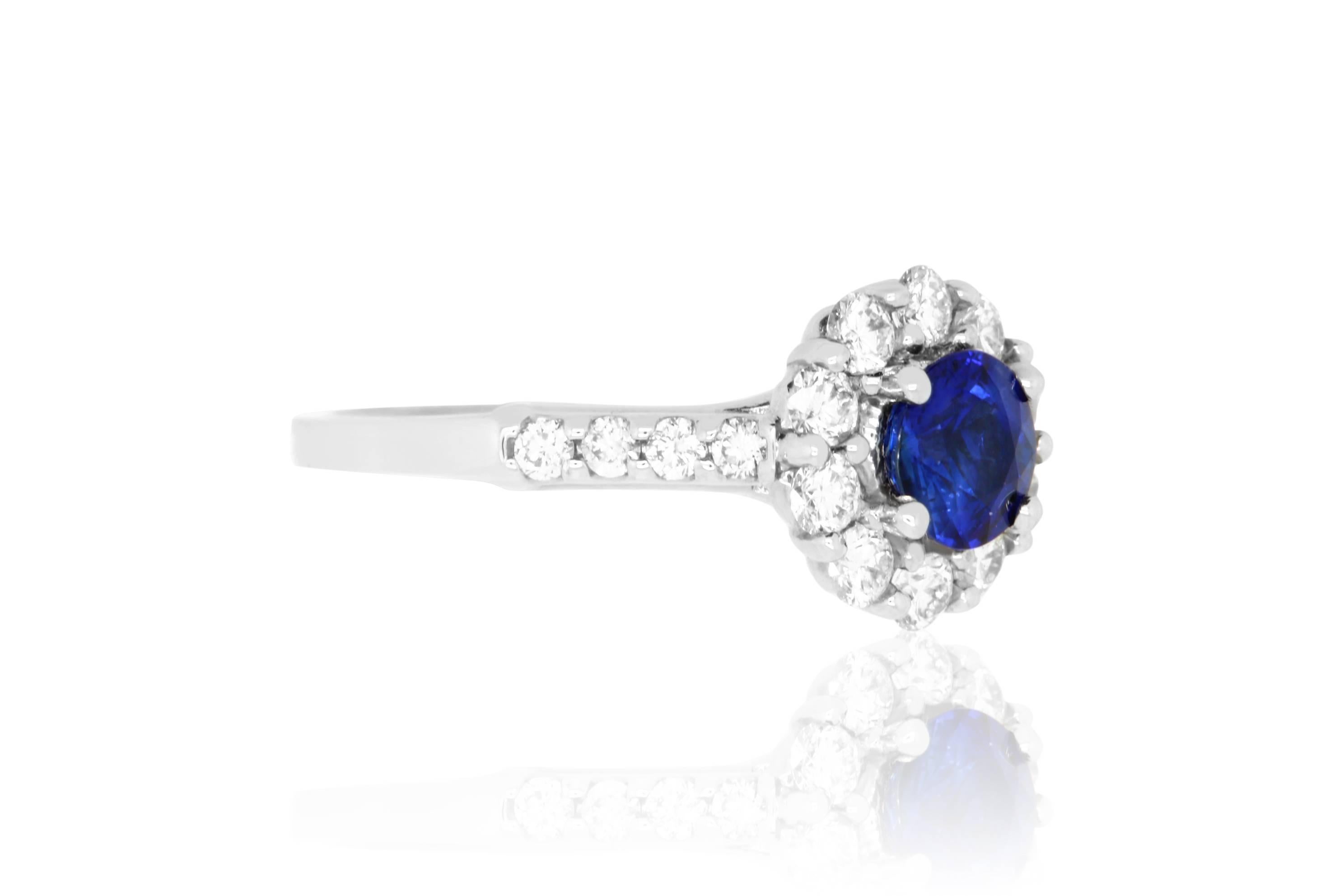 Material: 18k White Gold 
Center Stone Details:  1.08 Carat Blue Sapphire
Mounting Diamond Details: 18 Round White Diamonds Approximately 0.85 Carats - Clarity: SI / Color: H-I
Ring Size: Size 6.5 (can be sized)

Fine one-of-a kind craftsmanship
